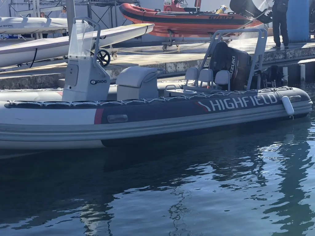 Highfield OM 590 — Bateau semi-rigide gris amarré, photographié de profil dans un port.