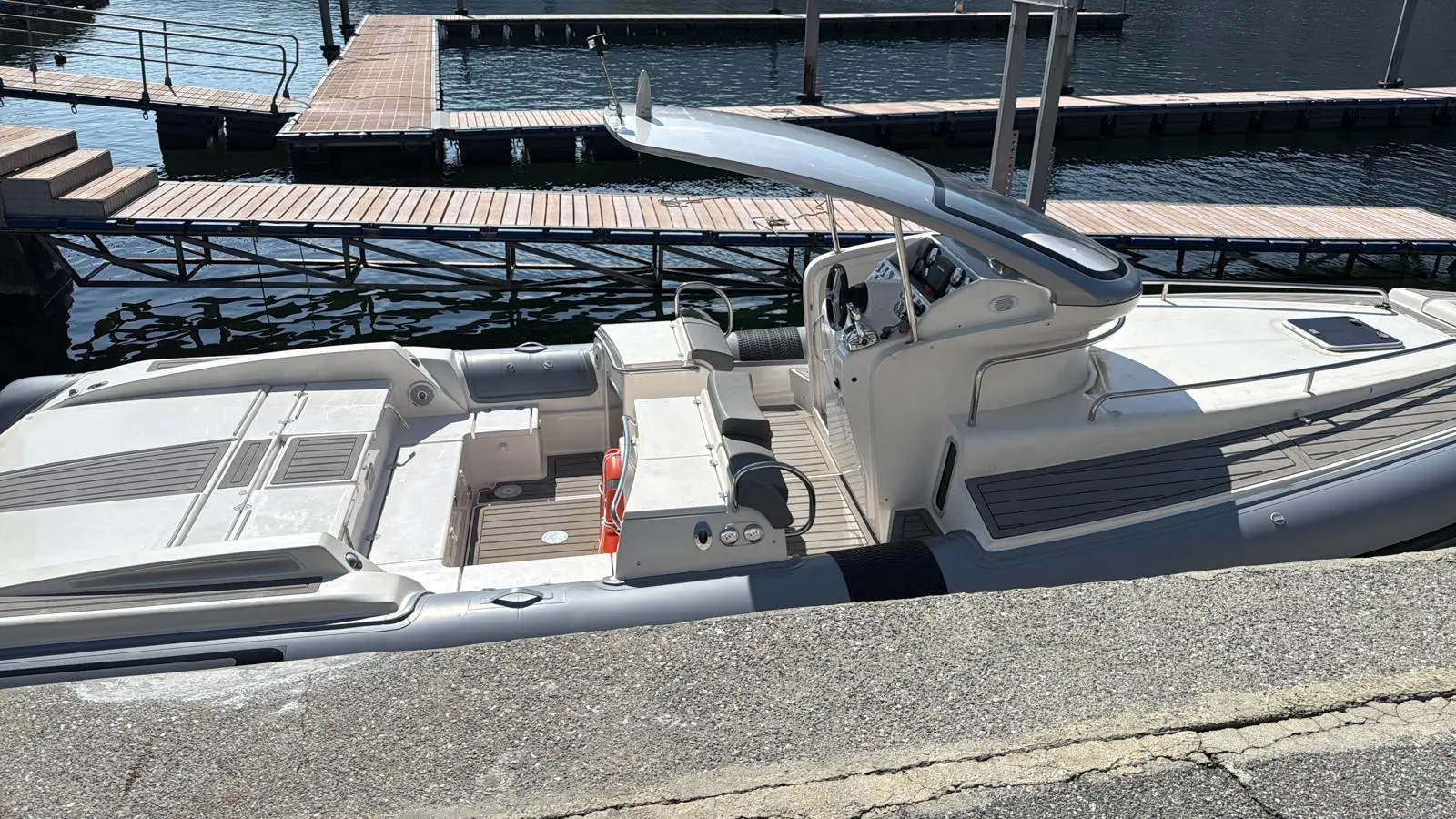 Pirelli Pzero 1100 Open — Vue plongeante d’un bateau pneumatique blanc amarré à un ponton.