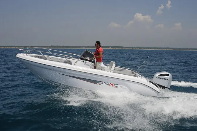 4XC H22CC — Bateau à moteur blanc naviguant à vive allure avec une personne à la barre.