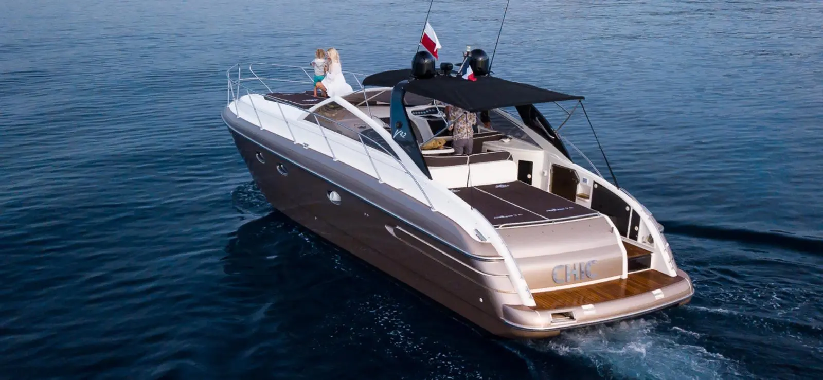 Princess V42 — Bateau à moteur vu de trois quarts arrière, naviguant sur une mer calme.