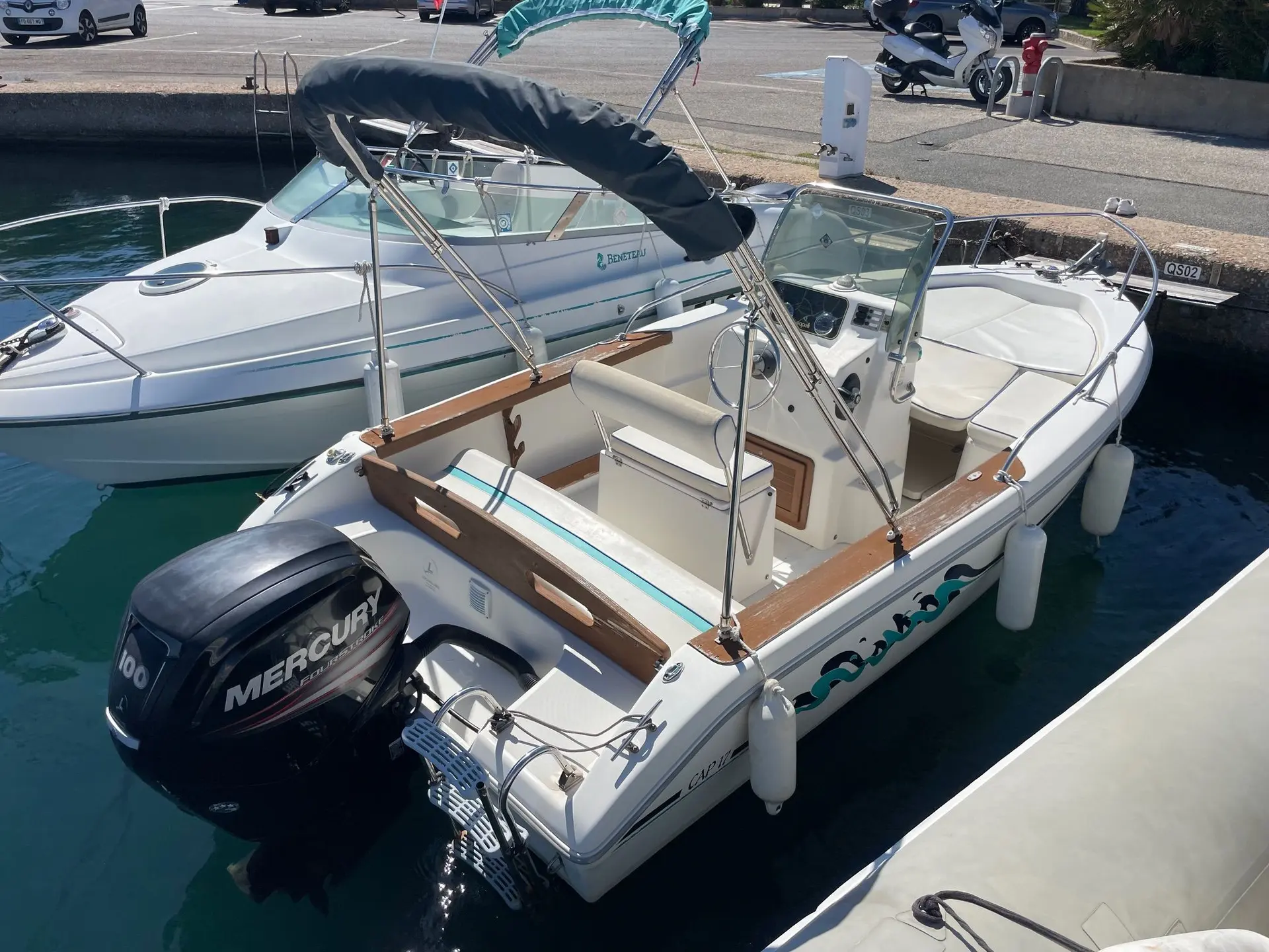 Capelli Cap 17 — Bateau à moteur blanc amarré, vu de trois quarts depuis le ponton.