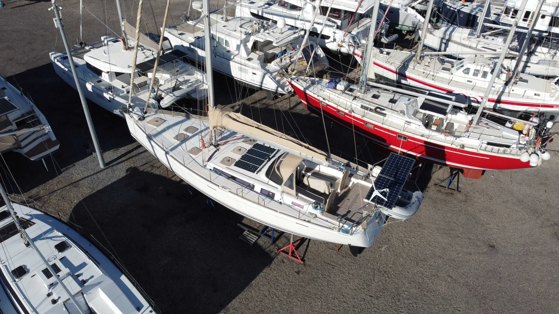 Dufour 525 — Voilier blanc photographié à sec dans un chantier nautique.