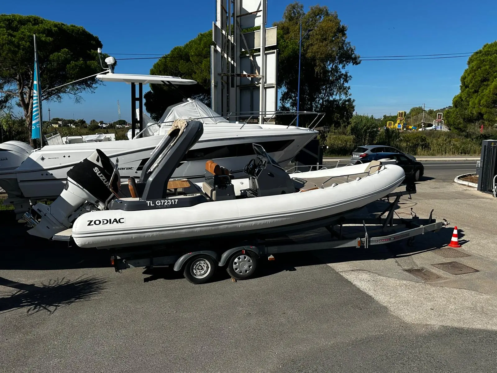 Lagoon 47 — Un semi-rigide blanc est présenté sur sa remorque devant un autre bateau.
