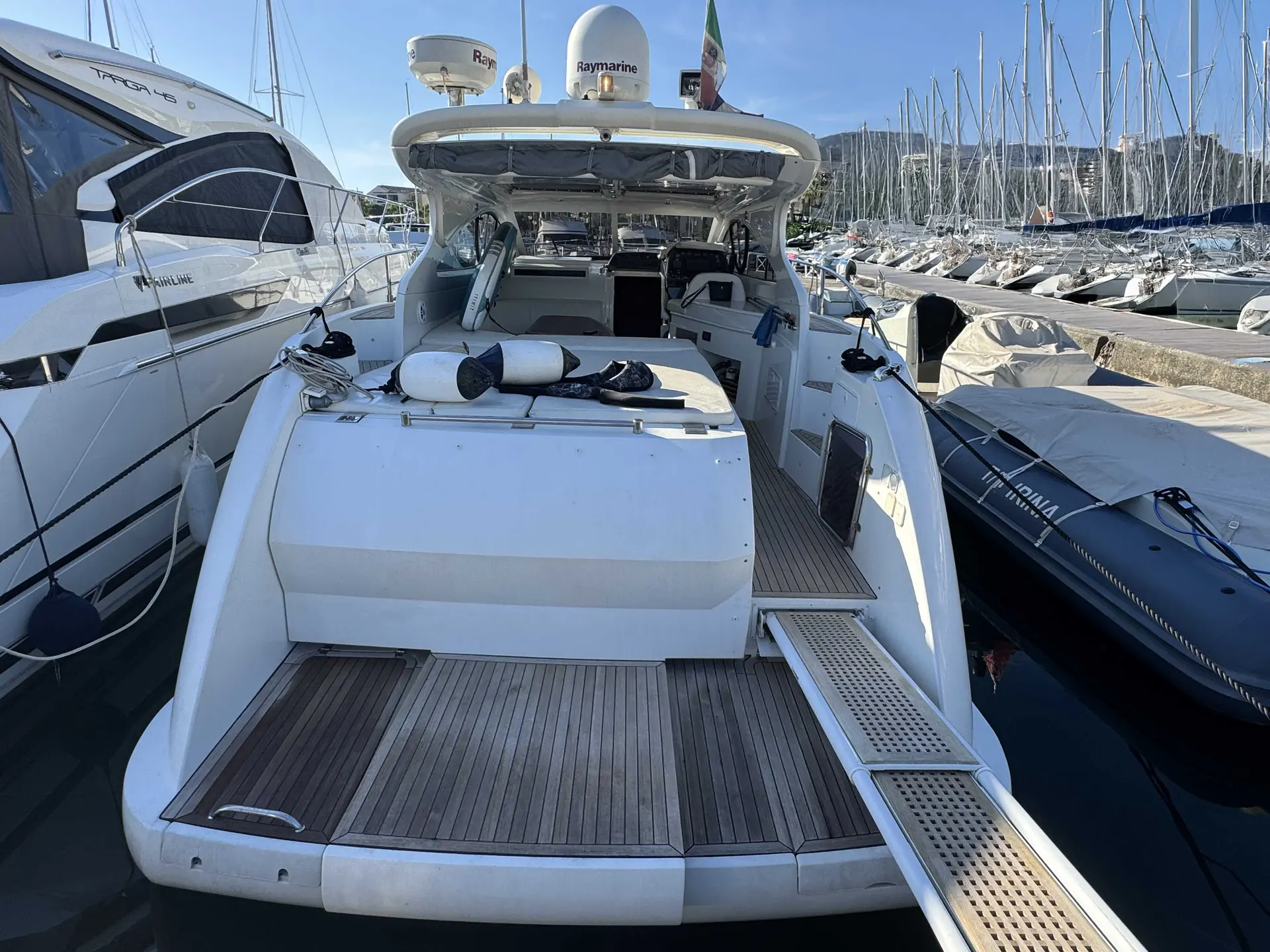 Della Pasqua DC 13 — Vue arrière du cockpit d’un bateau amarré dans une marina.