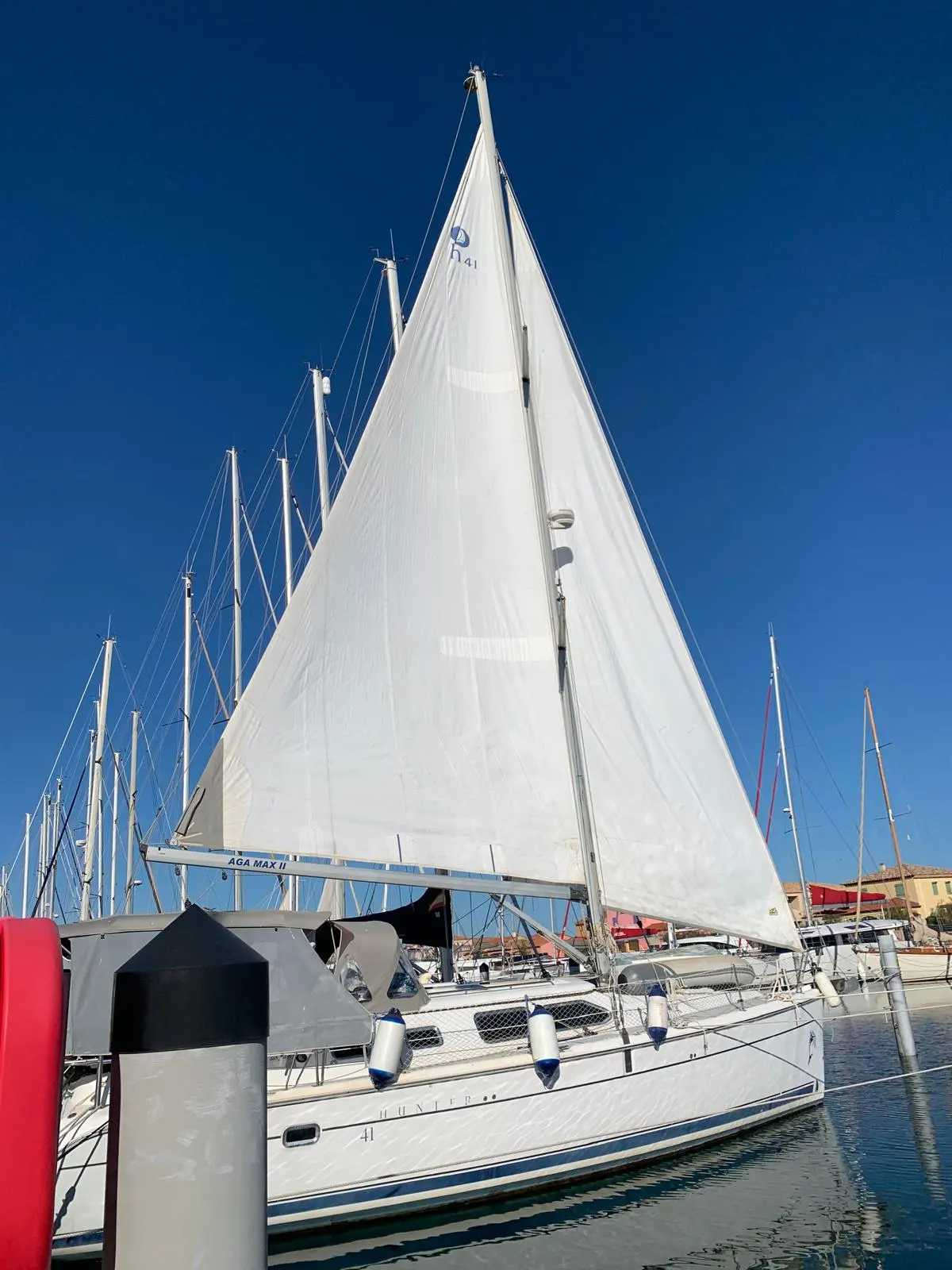 Hunter 41 DS — Voilier blanc amarré, photographié de profil avec sa grand-voile hissée.