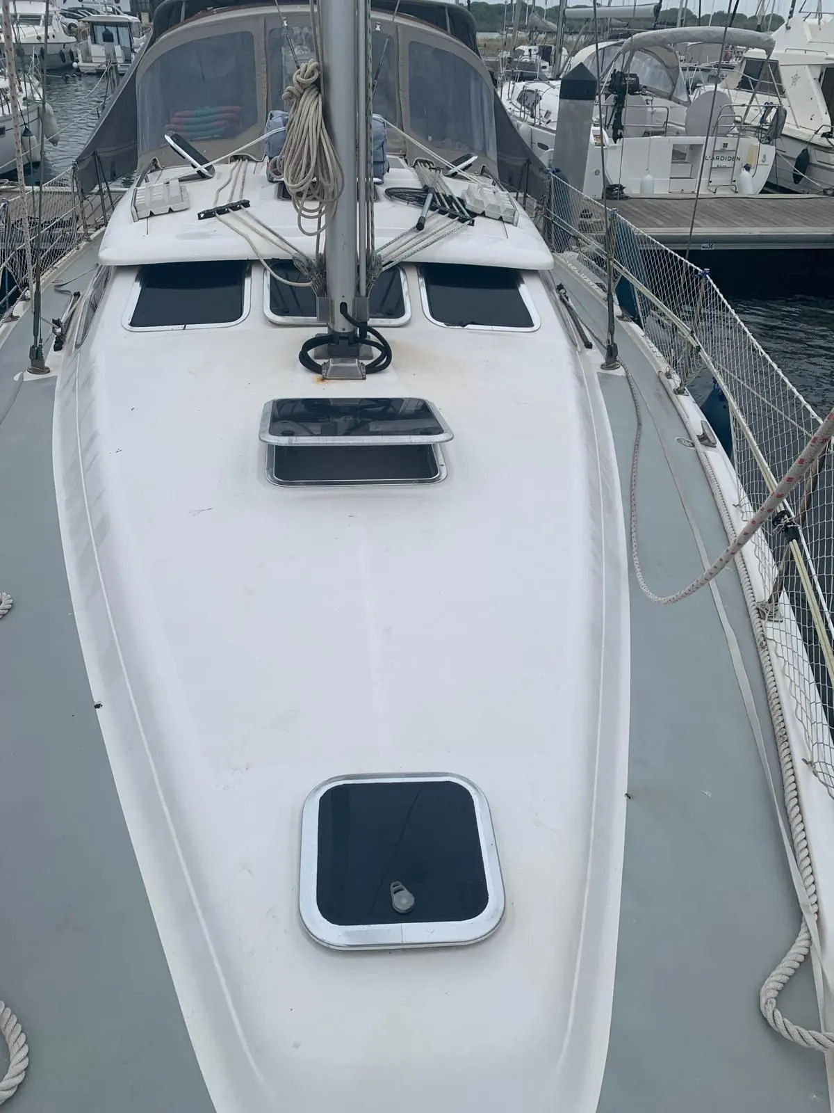 Hunter 41 DS — Vue plongeante du pont avant d’un voilier amarré, avec mât, panneaux et filières.