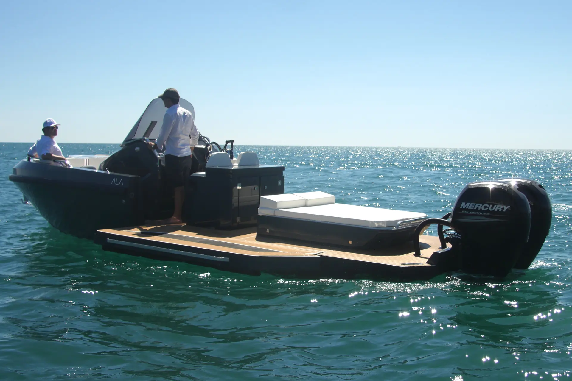 Ala Yacht Ala 8 — Bateau à moteur noir photographié en mer, avec deux personnes à bord.
