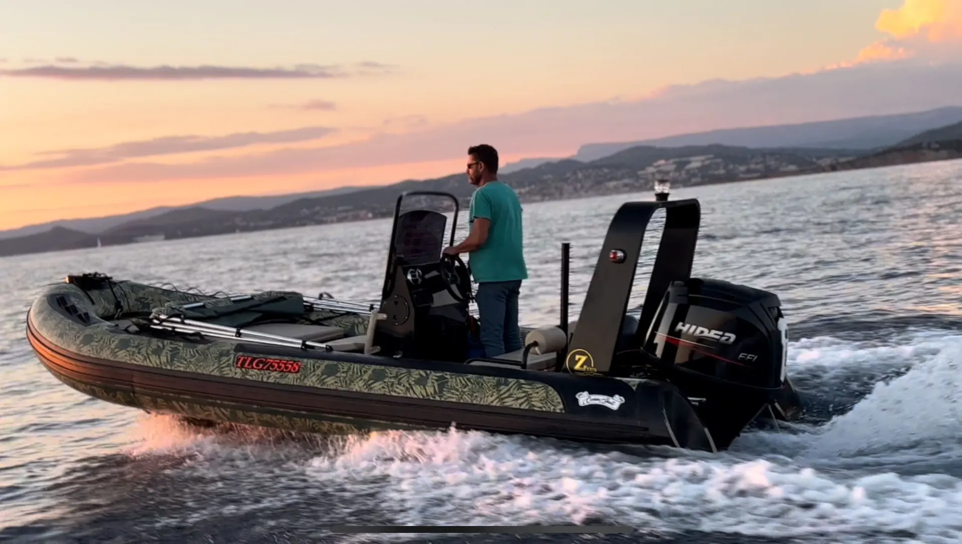 Océan Skull Zeus 550 — Bateau pneumatique naviguant au large au coucher du soleil, avec un homme à bord.