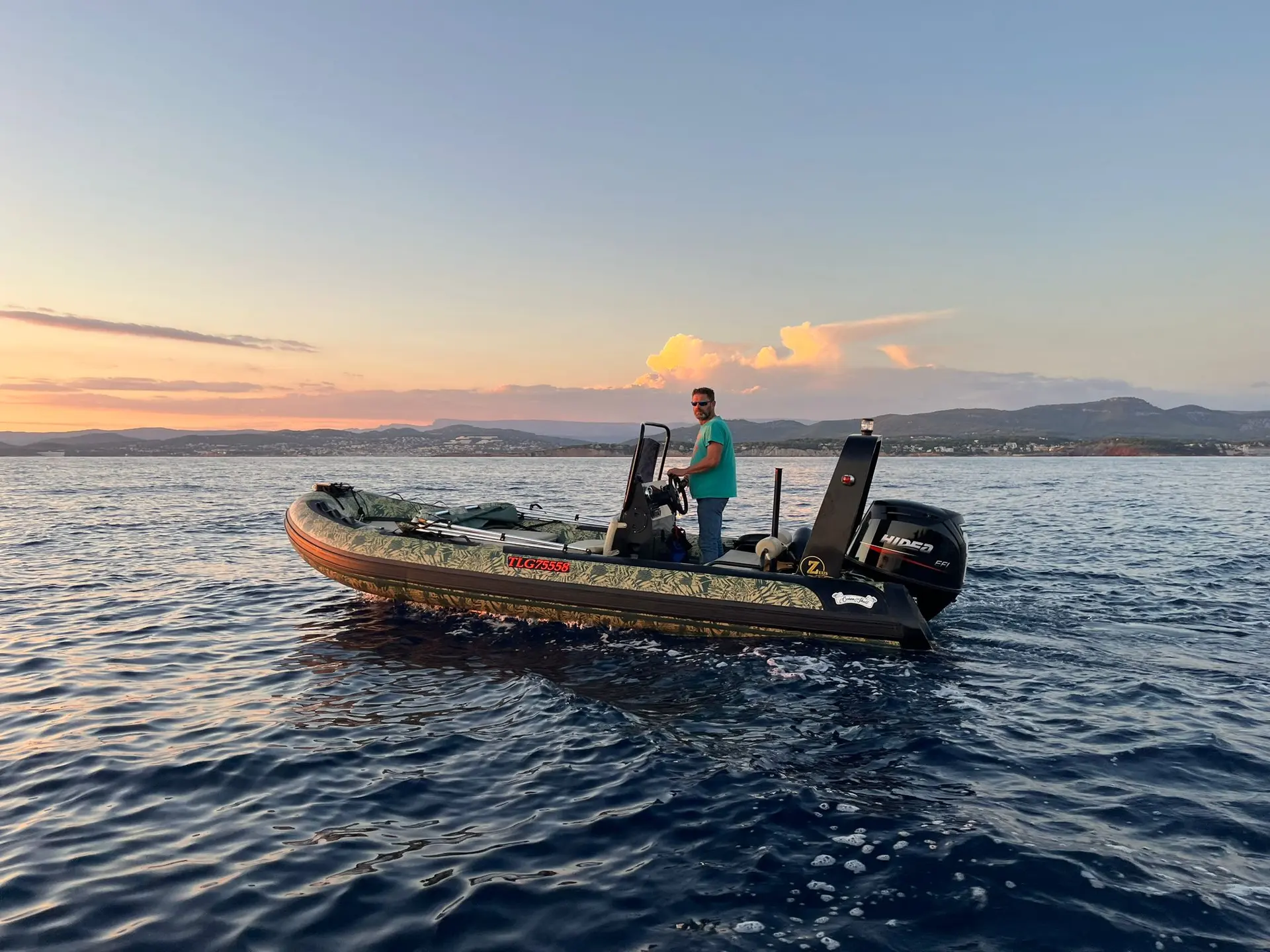 Océan Skull Zeus 550 — Bateau semi-rigide motorisé naviguant au coucher du soleil, avec un homme à bord.