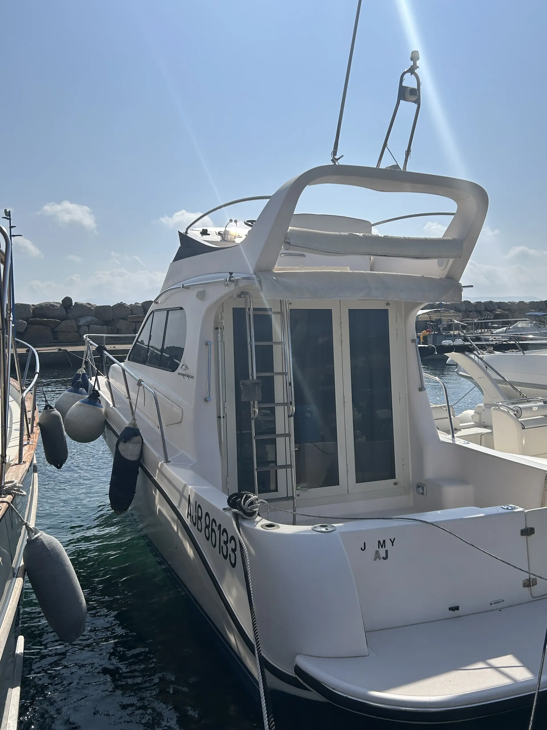 Intermare 30 Fly — Vue arrière trois-quarts d’un bateau blanc amarré dans un port.