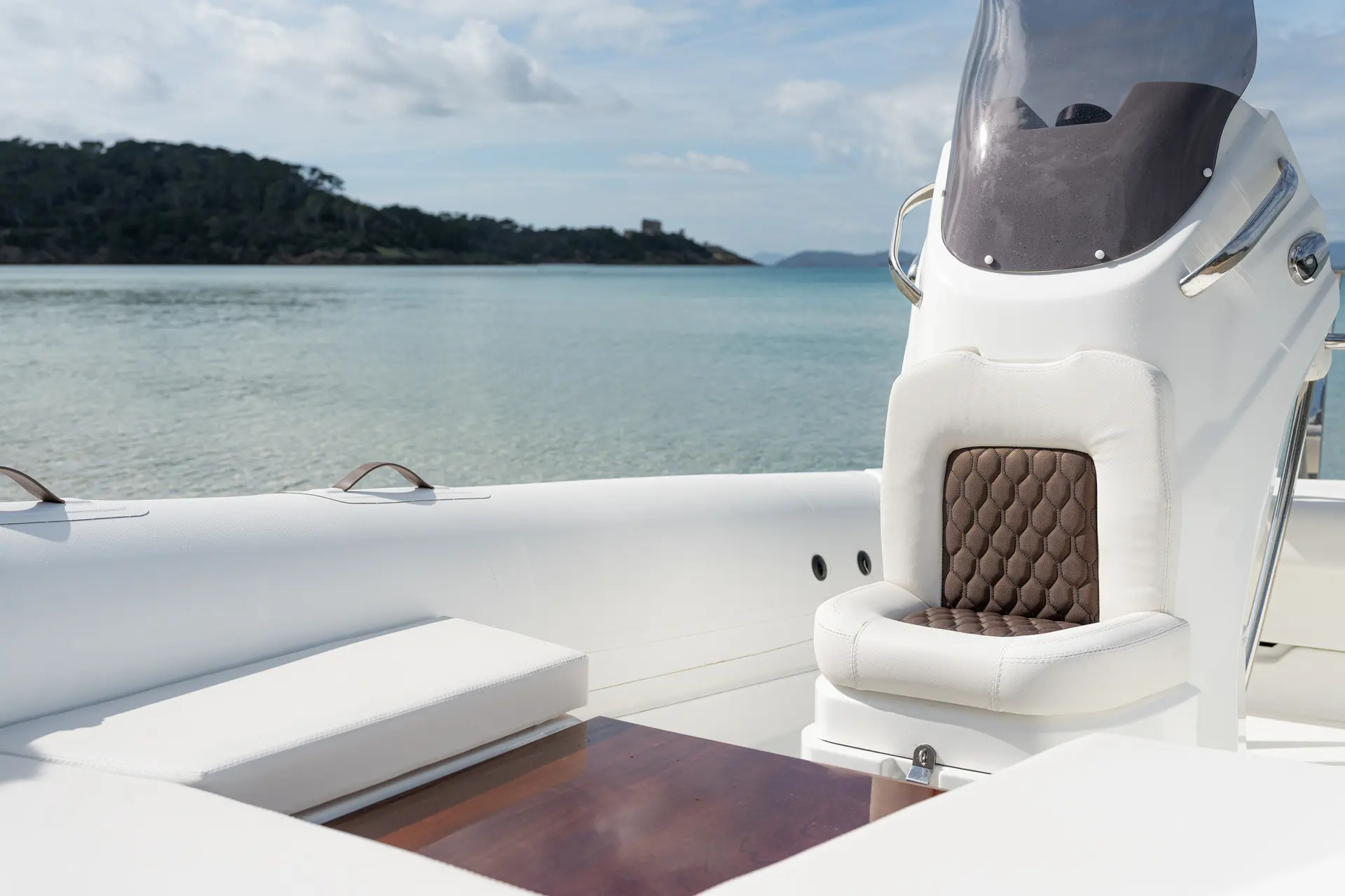 Estilo 18 — Vue du cockpit avec siège de pilotage, banquette et table en bois.