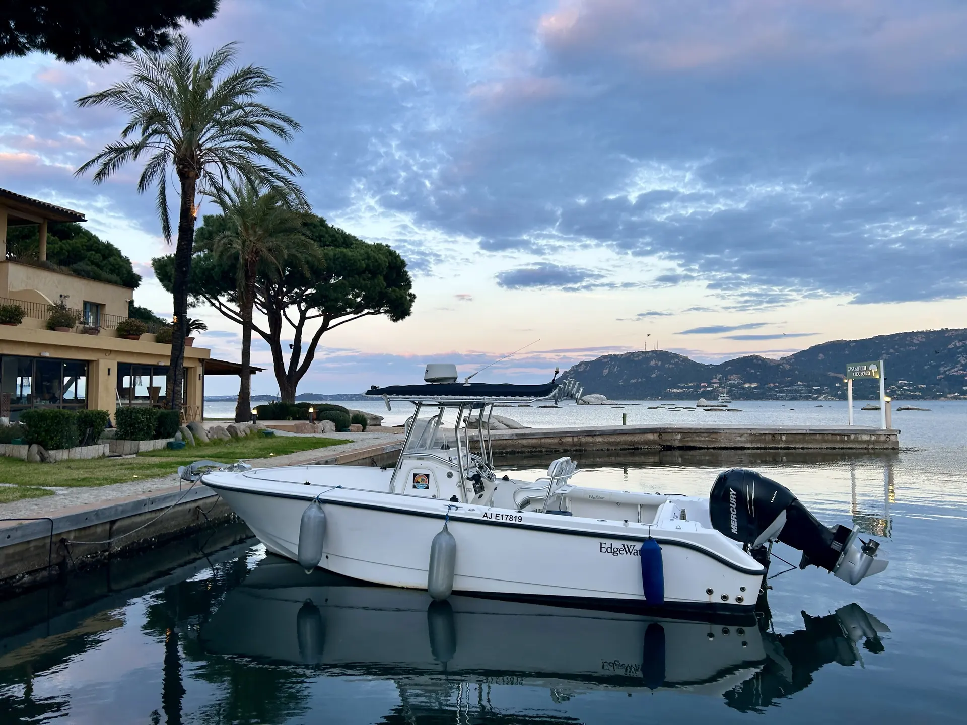 Edge Water 265 CC — Bateau à moteur blanc amarré dans un port, au pied d'une côte boisée.