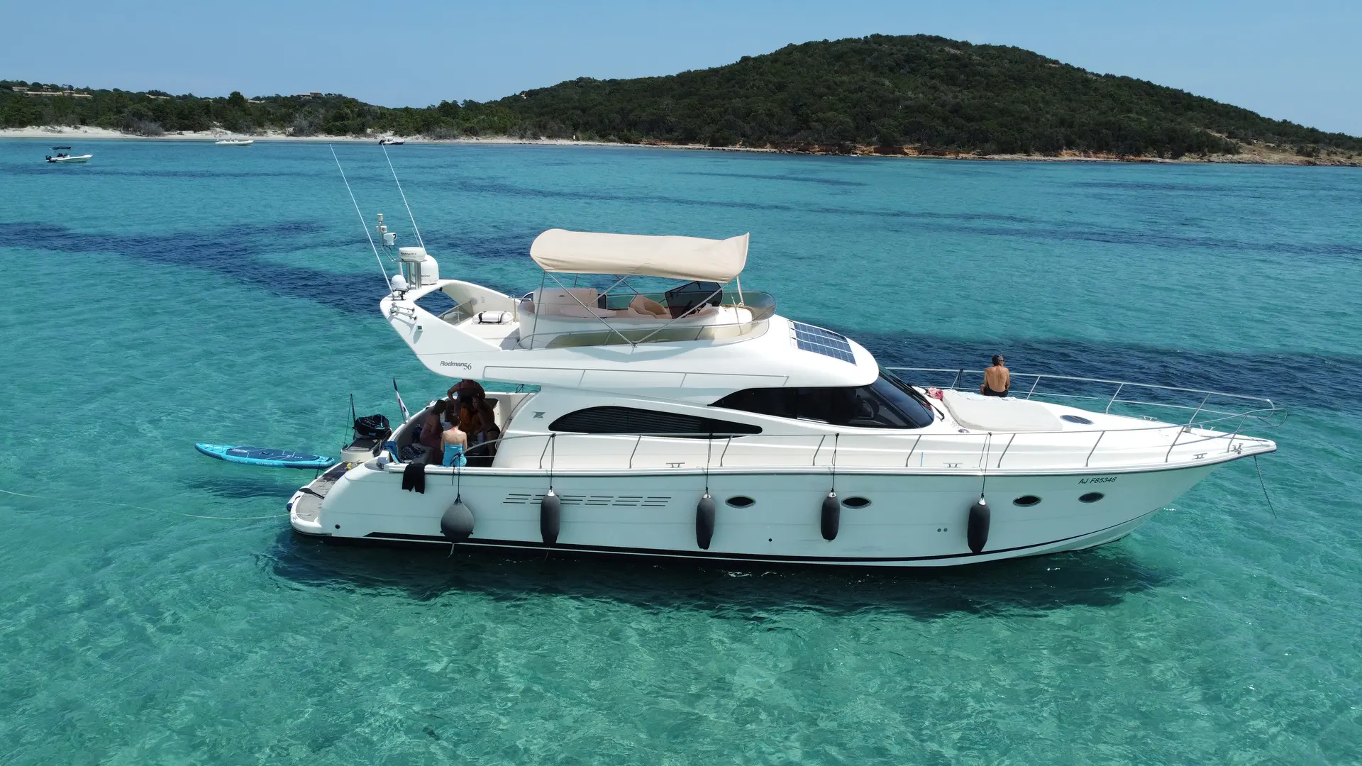 Rodman 56 — Vedette blanche vue de profil sur une mer turquoise, avec plusieurs personnes à bord.