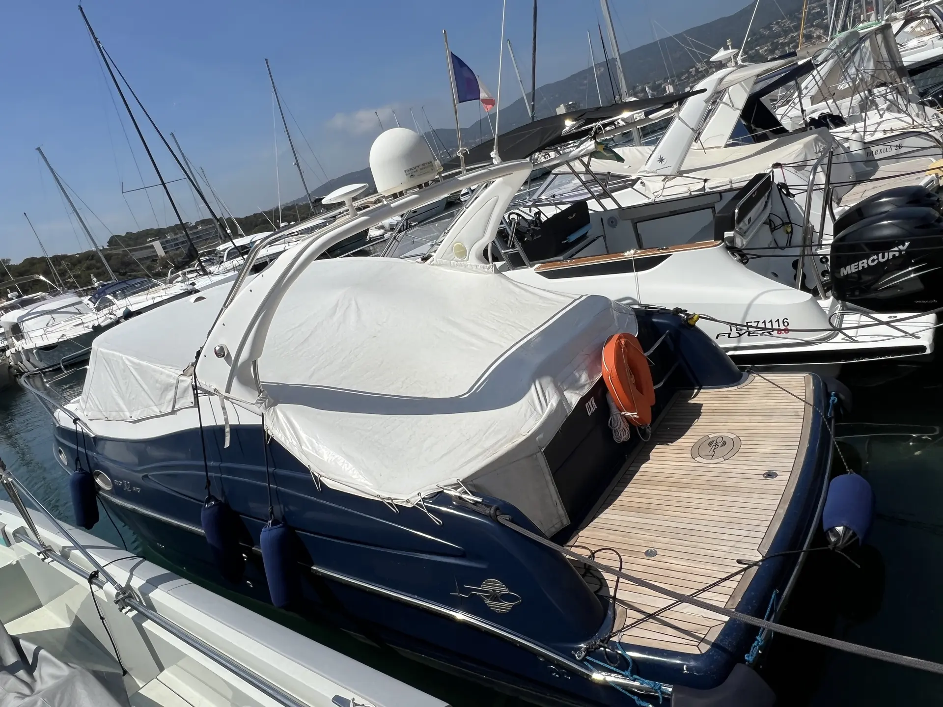 Rio 32 ART — Bateau à moteur bleu et blanc amarré dans une marina, vu depuis l’arrière.