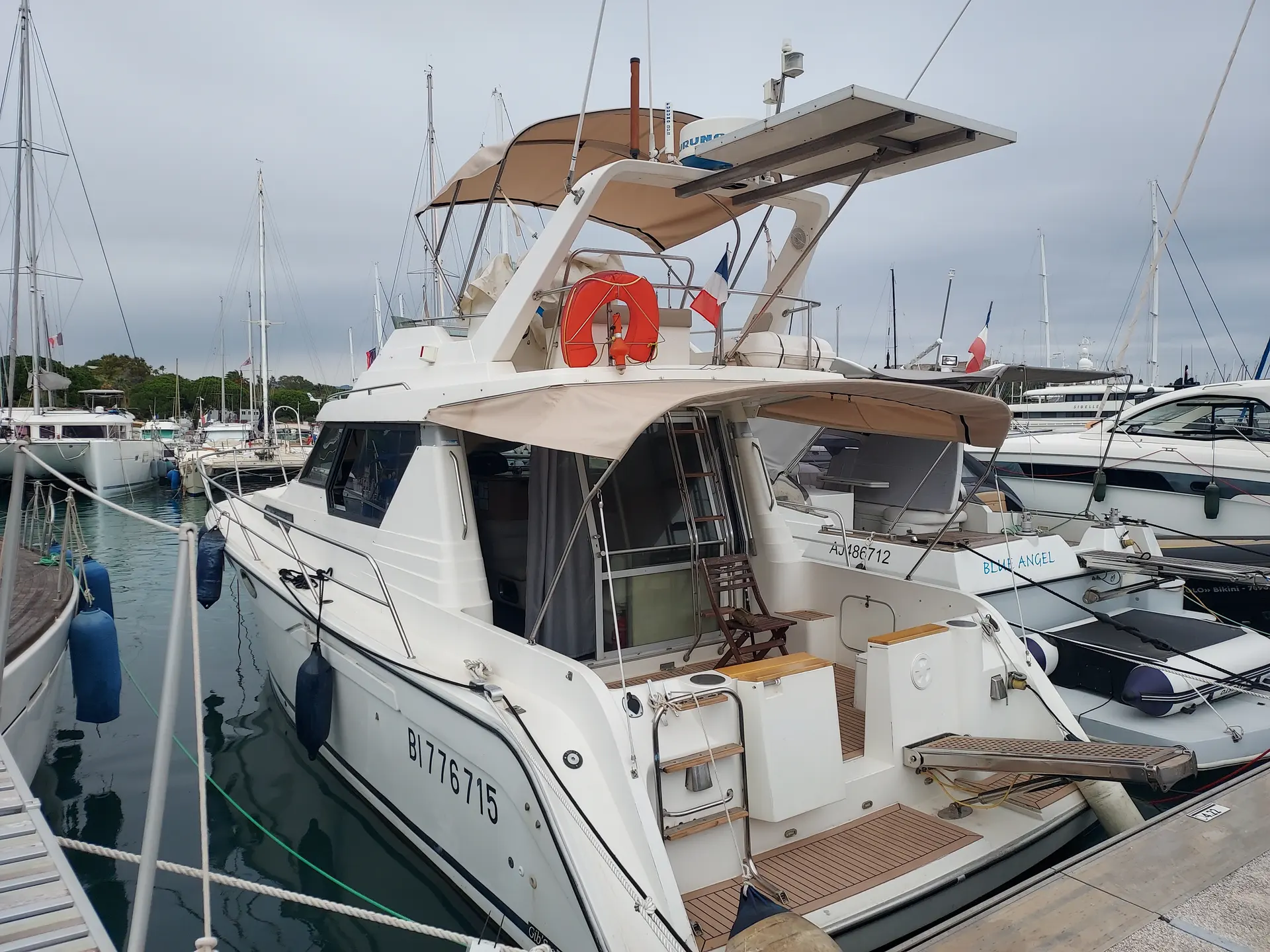 Gibert Marine Jamaica 38 — Vedette à moteur blanche vue de trois quarts arrière dans une marina.
