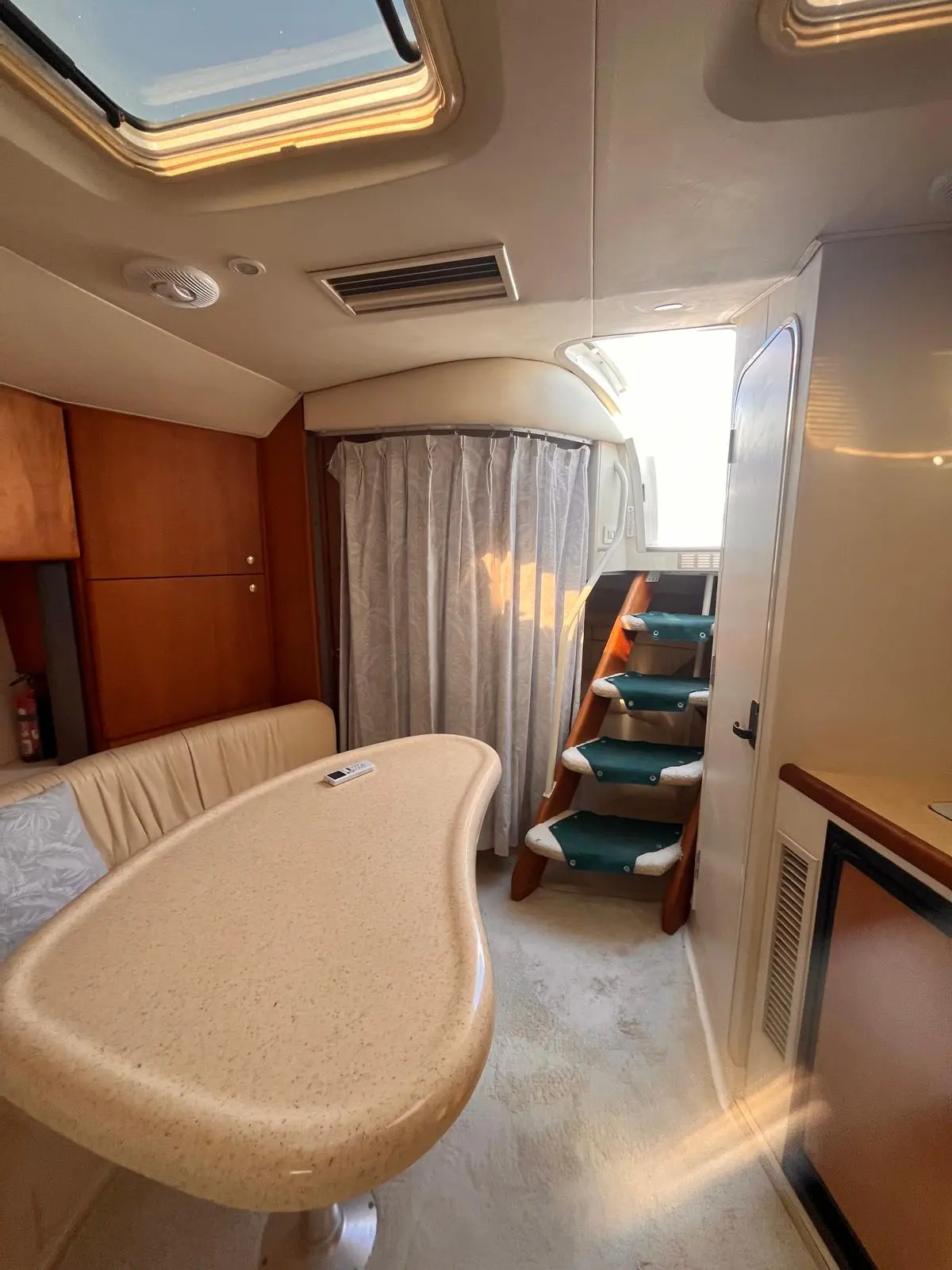 Silverton 360 — Vue intérieure d'un espace repas avec table, banquette et escalier vers l'avant.