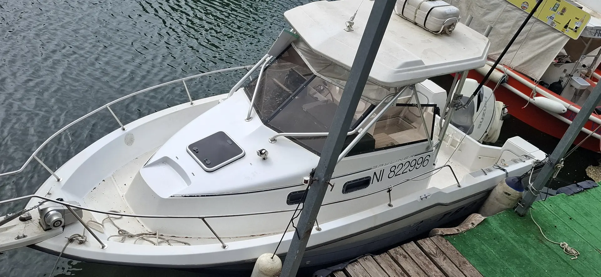 Bayliner Trophy 2502 — Bateau à moteur blanc amarré, vu en plongée depuis le quai.