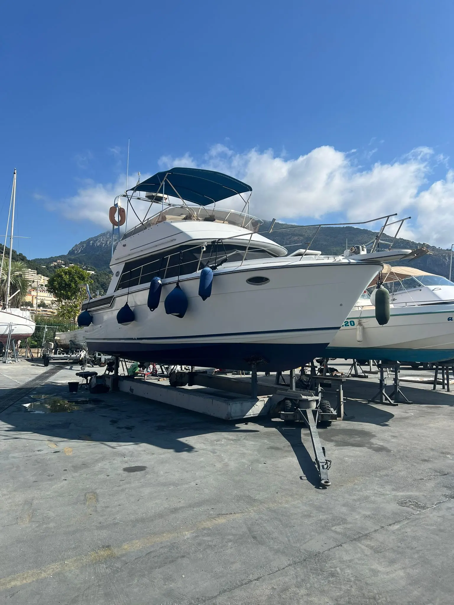 Carver 850 Fly — Bateau à moteur blanc photographié sur bers dans une marina, vue trois-quarts avant.