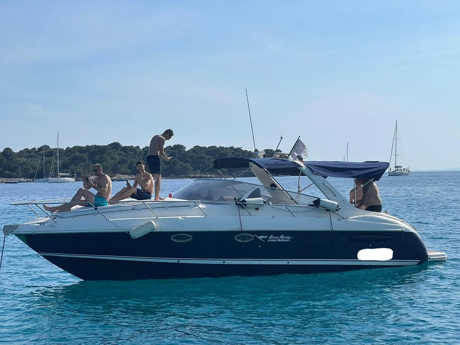 Airon Marine 301 — Bateau à moteur blanc et bleu vu de profil, avec plusieurs personnes à bord.