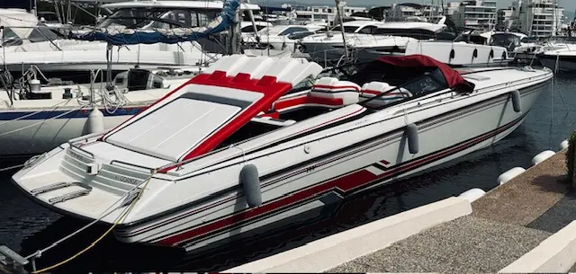 Formula 419 SRI — Bateau à moteur blanc et rouge amarré dans une marina, vu de trois quarts.