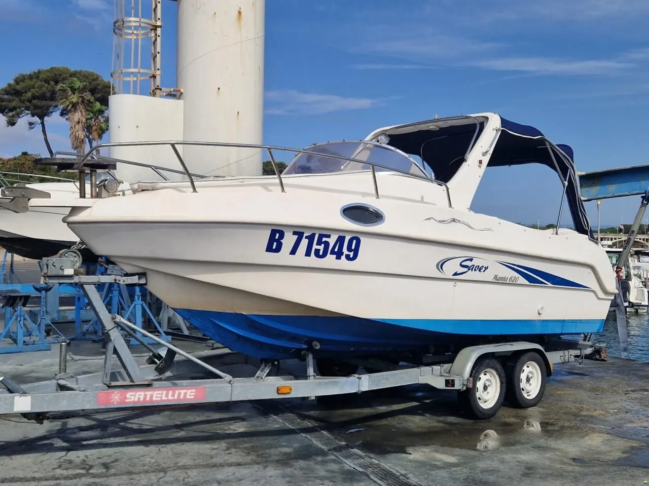 Saver 620 Manta — Bateau à moteur blanc et bleu vu de profil sur une remorque au chantier naval.
