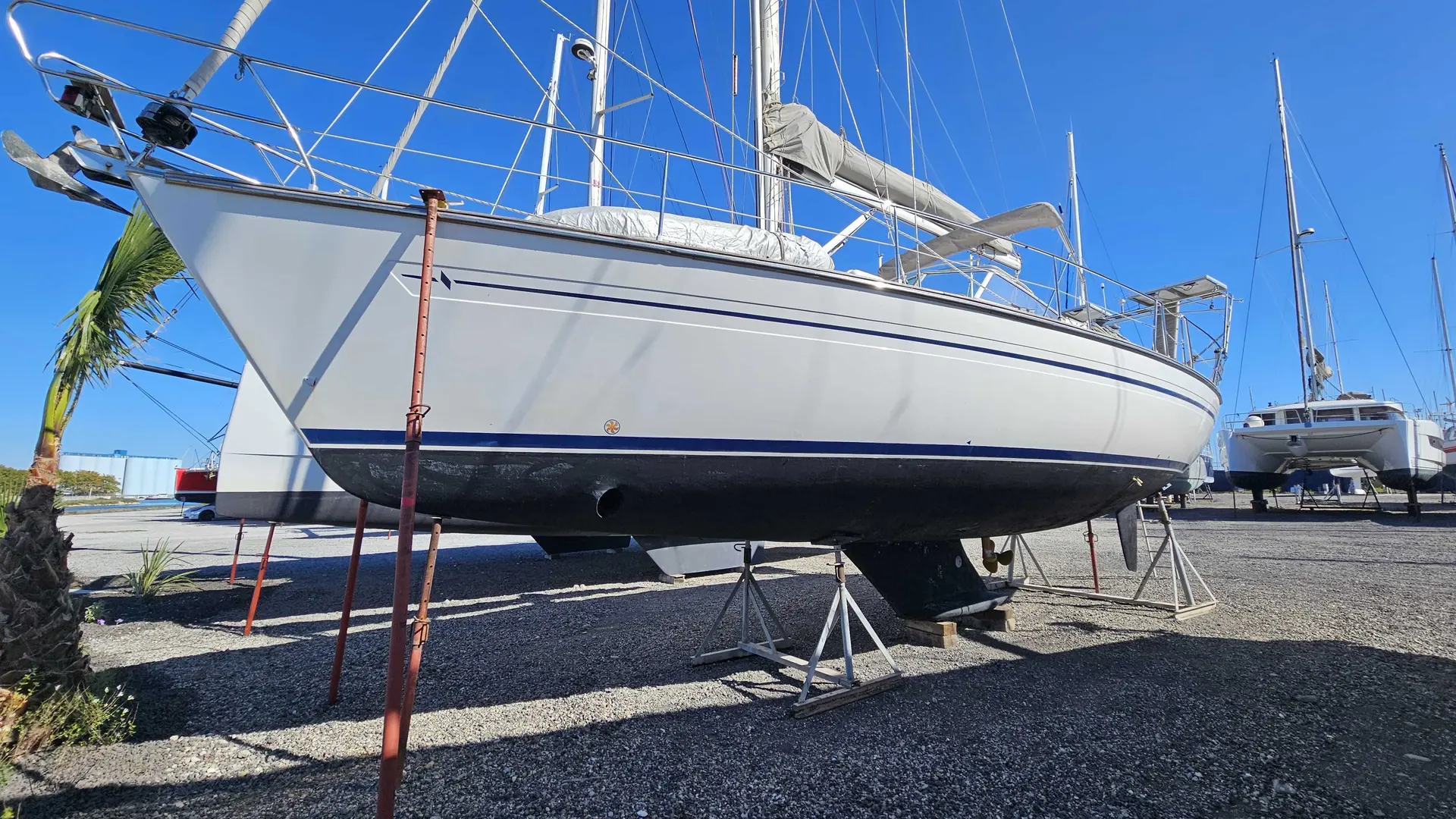 Bavaria OCEAN 40 CC — Voilier blanc à coque bleue présenté à terre sur des bers.