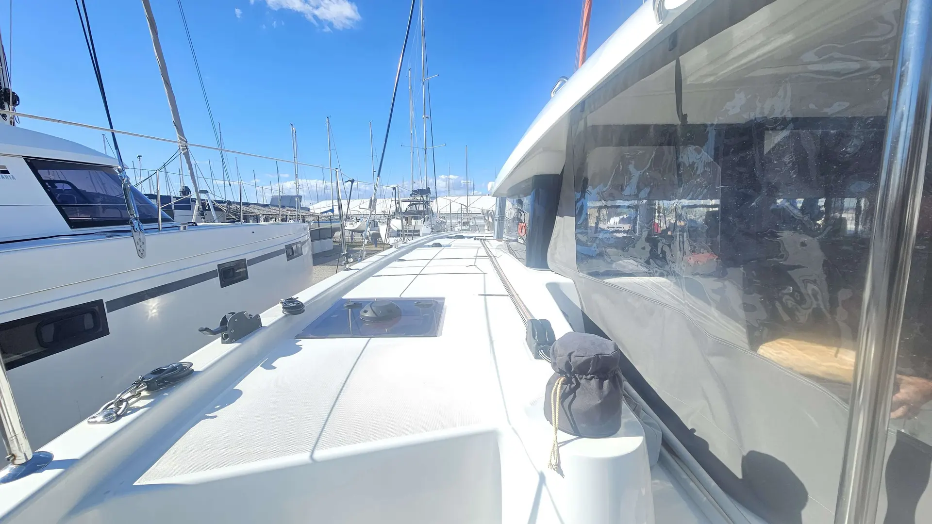 Beneteau Excess 11 — Vue du pont avant d’un bateau amarré dans un port de plaisance.