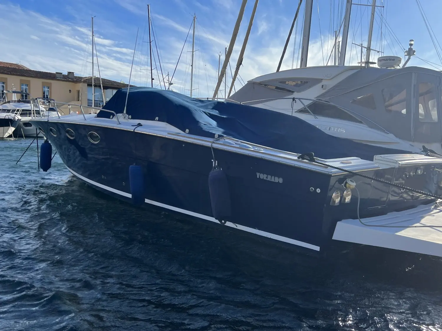 Tornado Marine Tornado 38 — Bateau à moteur bleu amarré dans un port, vu de trois quarts bâbord.