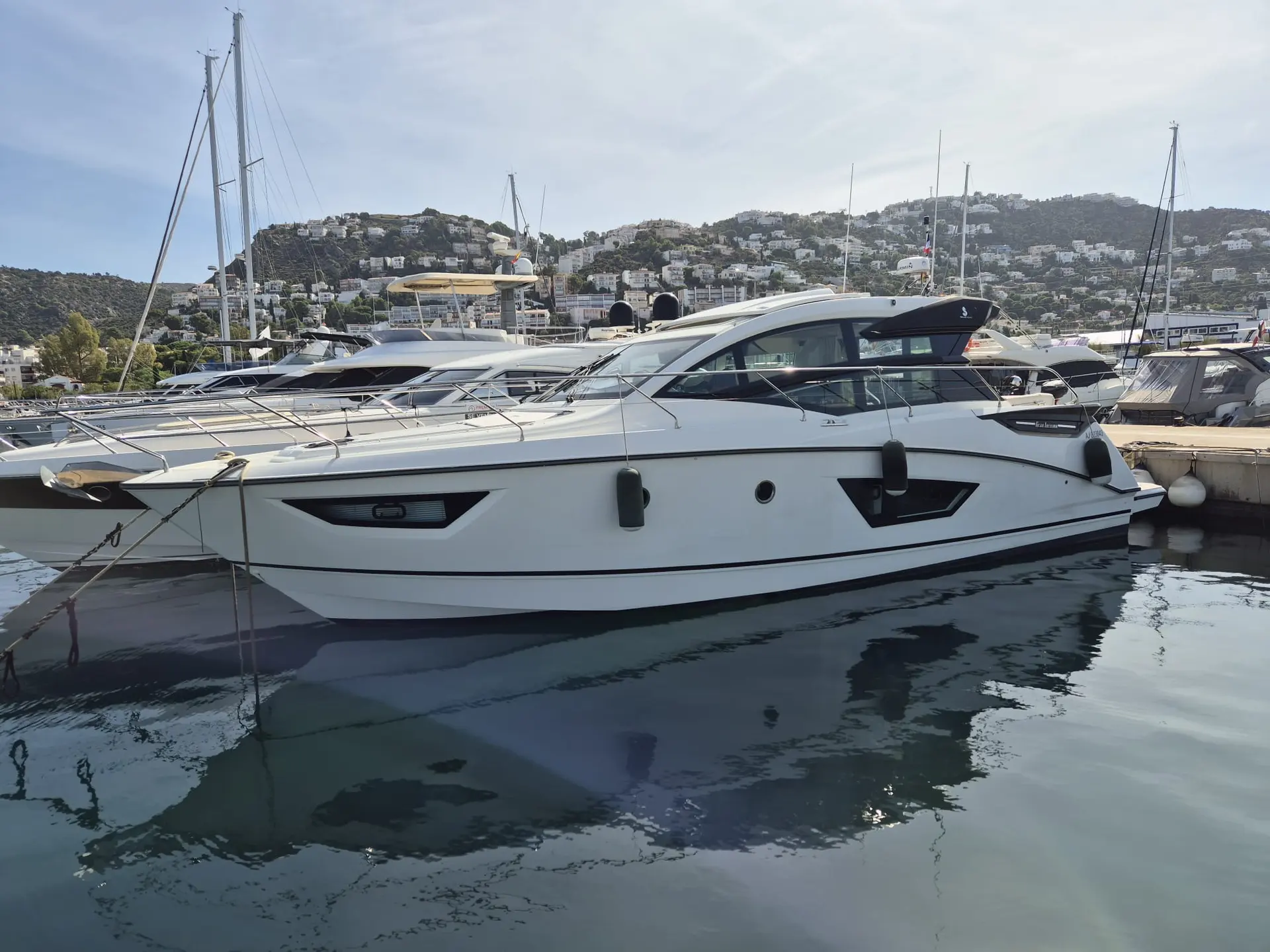 Beneteau Gran Turismo 50 — Bateau à moteur blanc vu de profil, amarré dans une marina.