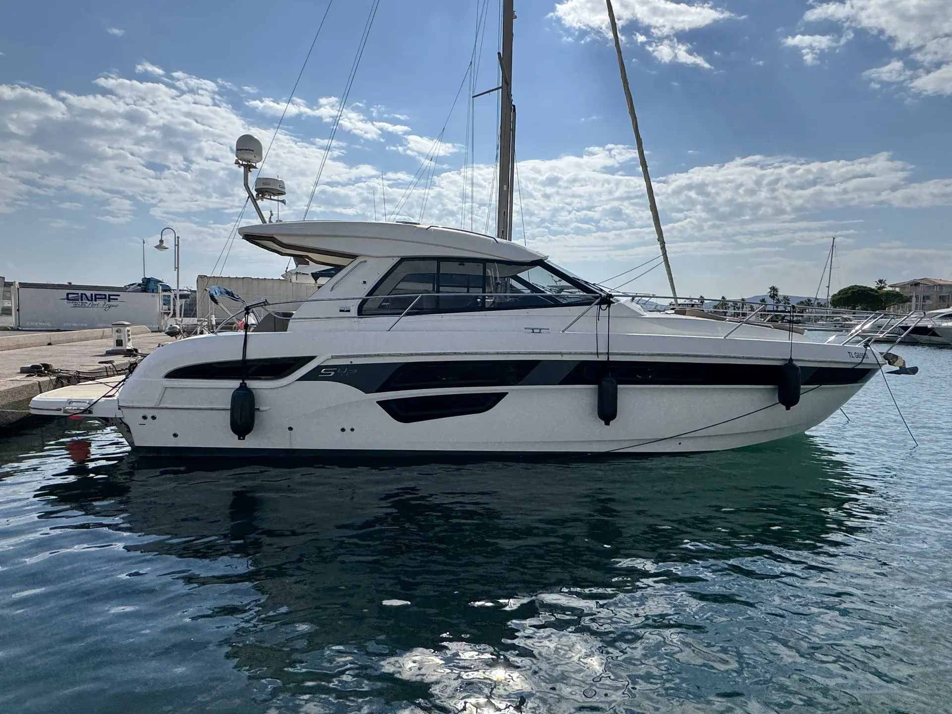 Bavaria Sport 450 — Bateau à moteur blanc vu de profil dans une marina, amarré au quai.