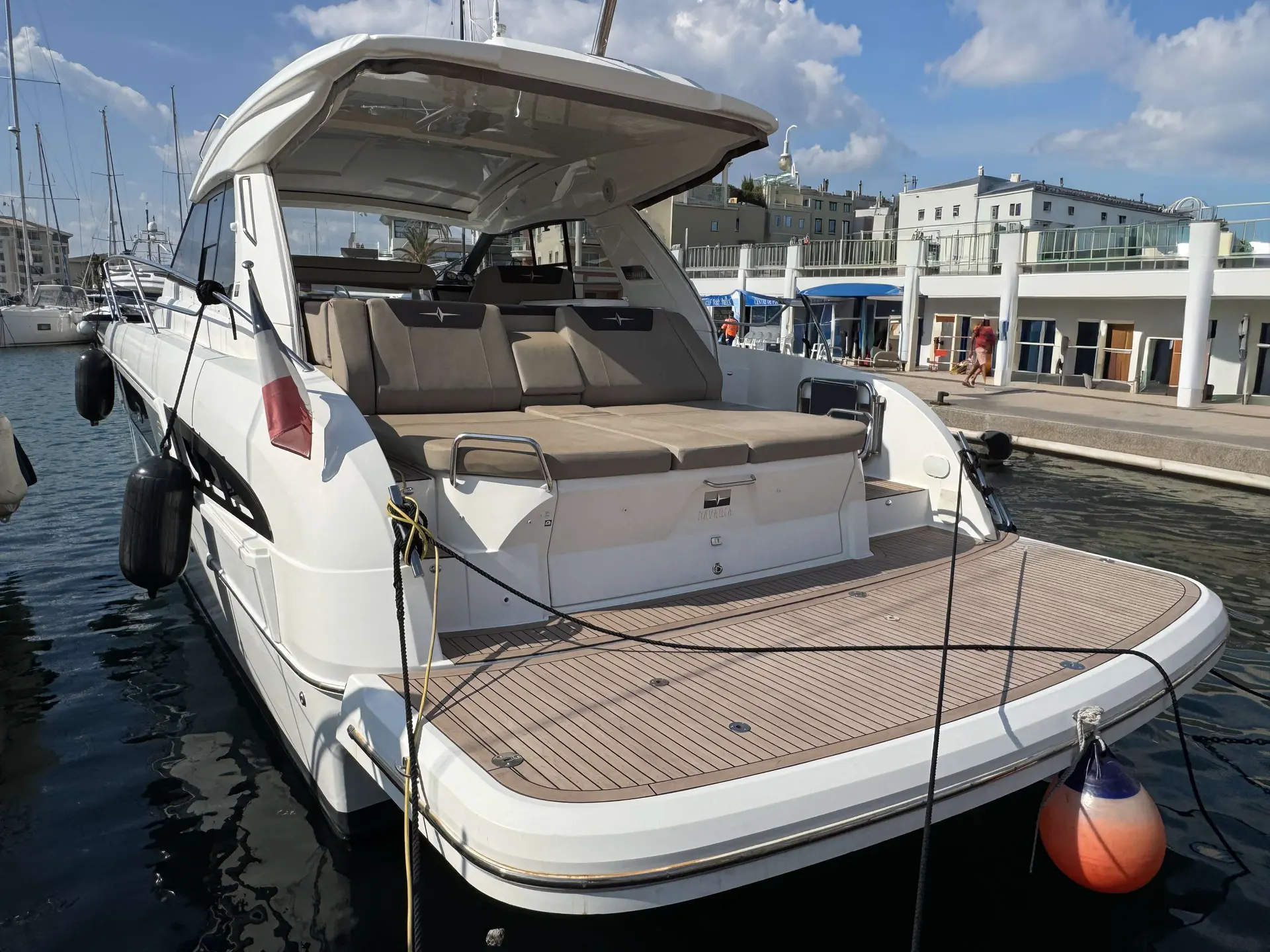 Bavaria Sport 450 — Vue arrière trois-quarts d’un bateau à moteur amarré dans un port.