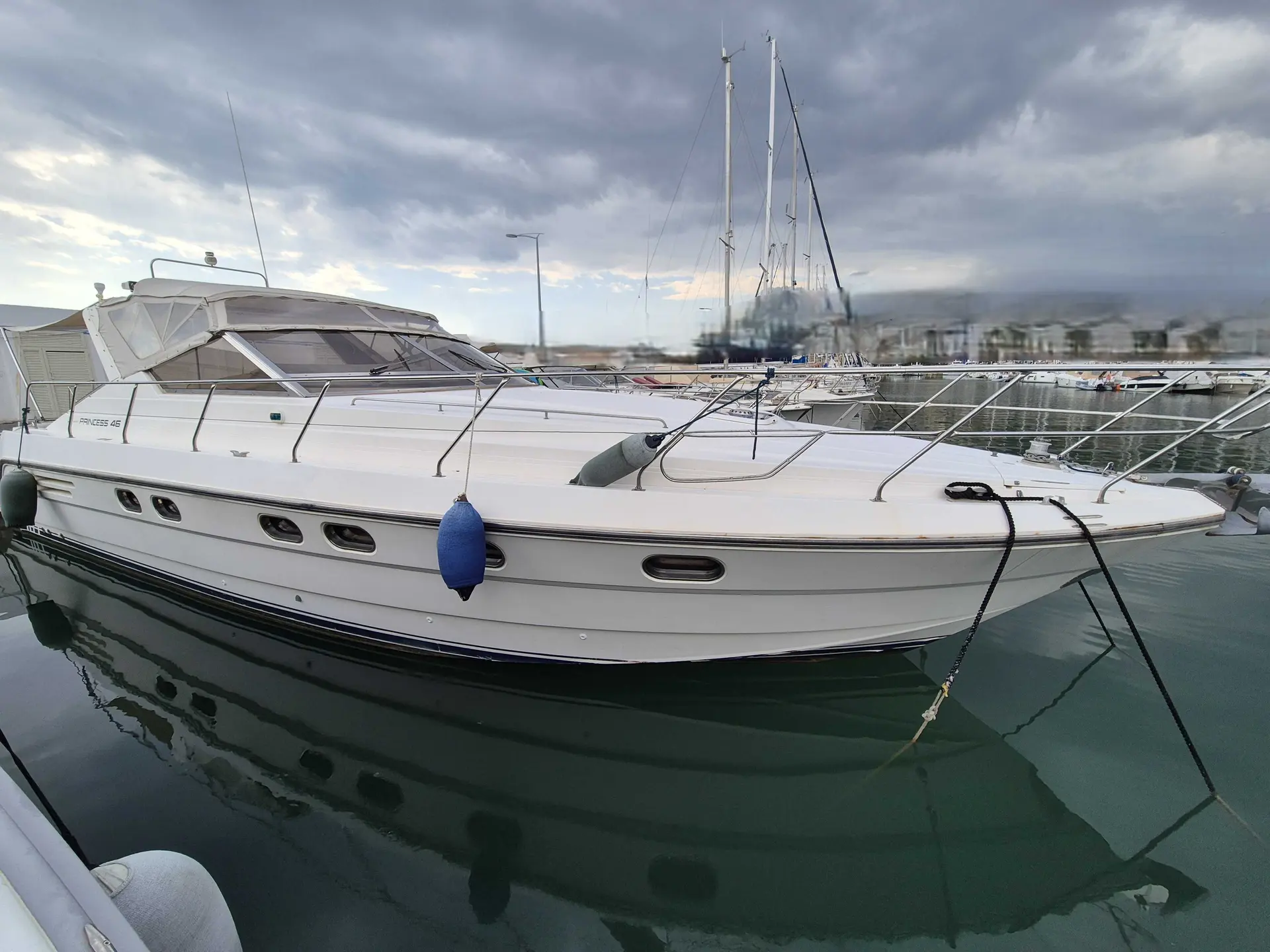 Princess Riviera 46 — Yacht à moteur blanc amarré dans une marina, vu de trois quarts bâbord.