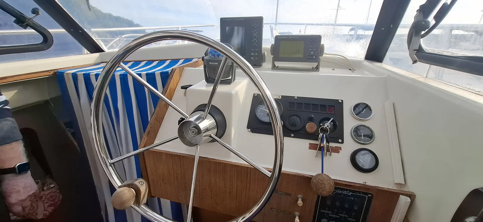Gibert Marine Gib Sea 64 — Poste de pilotage avec barre à roue, instruments et commandes visibles.