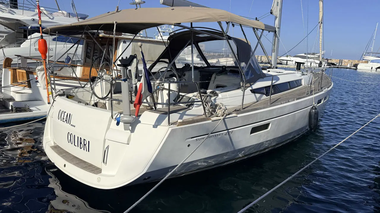 Jeanneau Sun Odyssey 479 — Voilier blanc amarré, photographié de trois quarts arrière dans une marina.