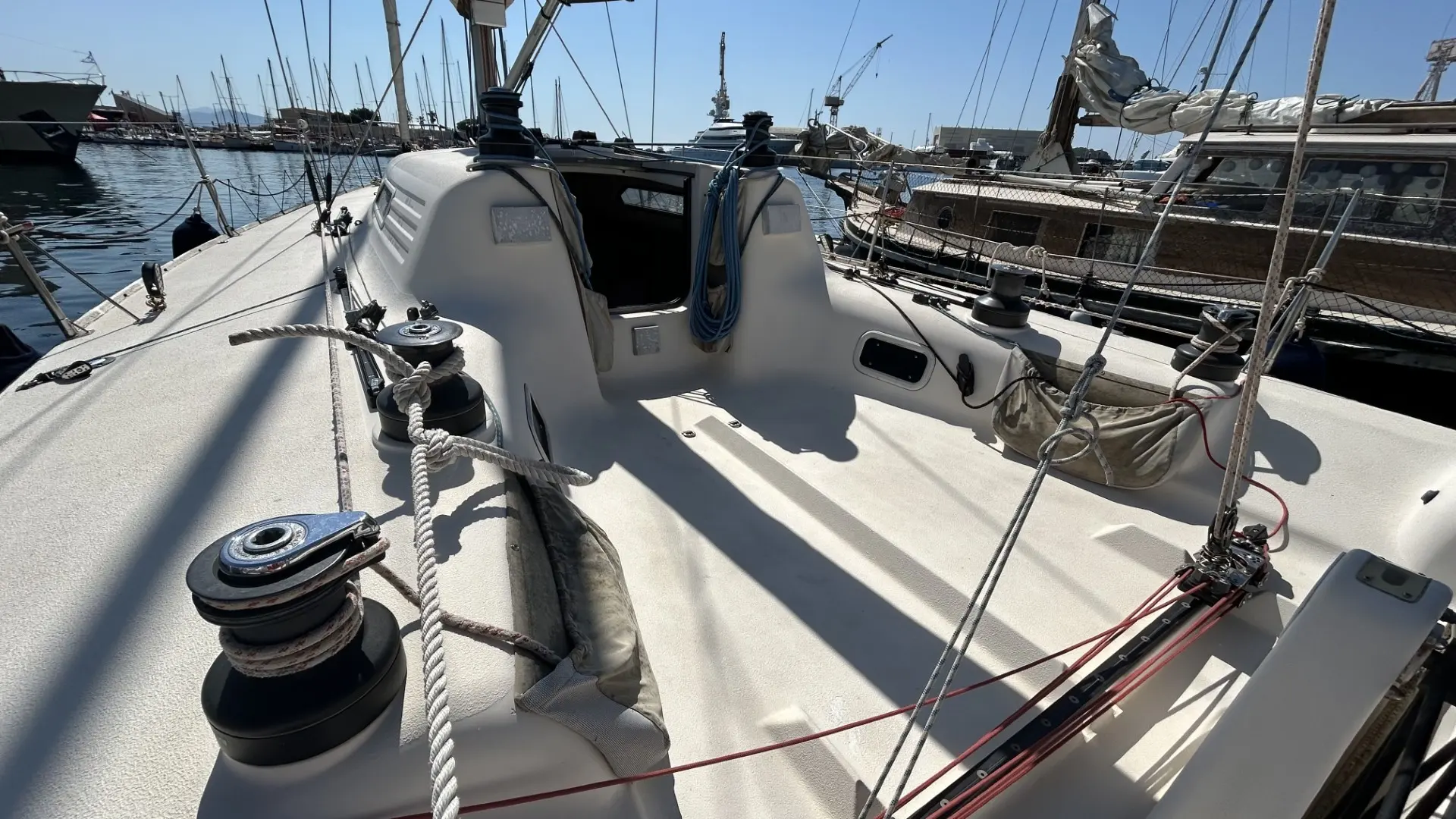 X-Yachts IMX 38 — Vue du cockpit et du pont d’un voilier amarré au port.