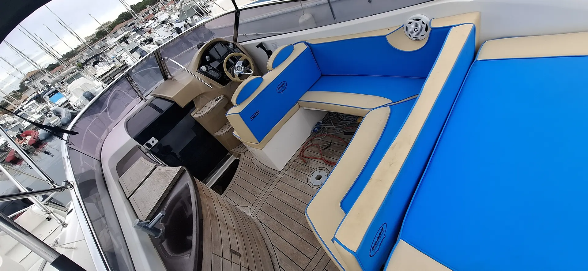 Sessa Marine S26 — Vue plongeante du cockpit avec poste de pilotage, banquettes et bain de soleil.