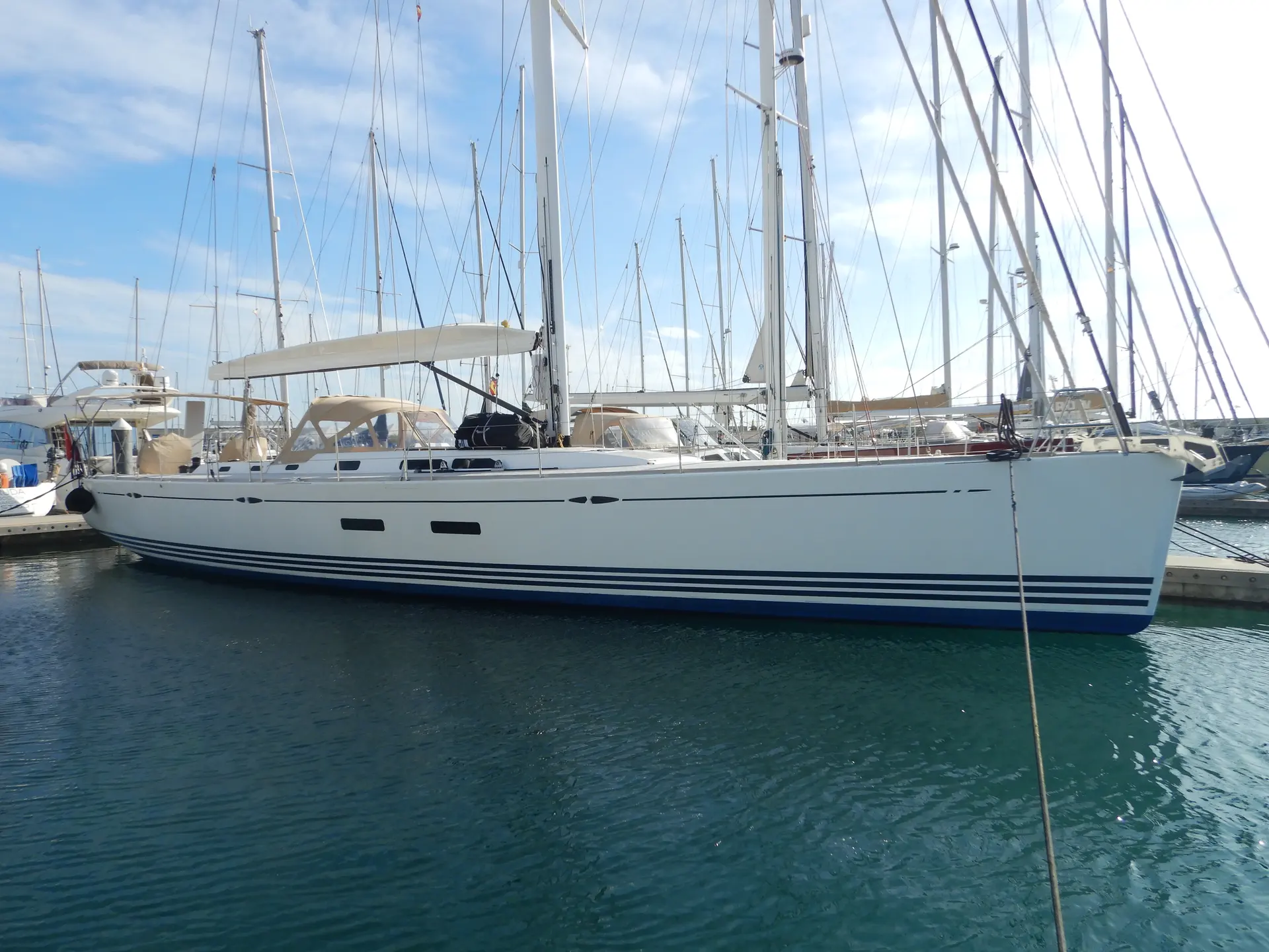 X-Yachts X-65 — Voilier blanc amarré dans une marina, vu de profil.