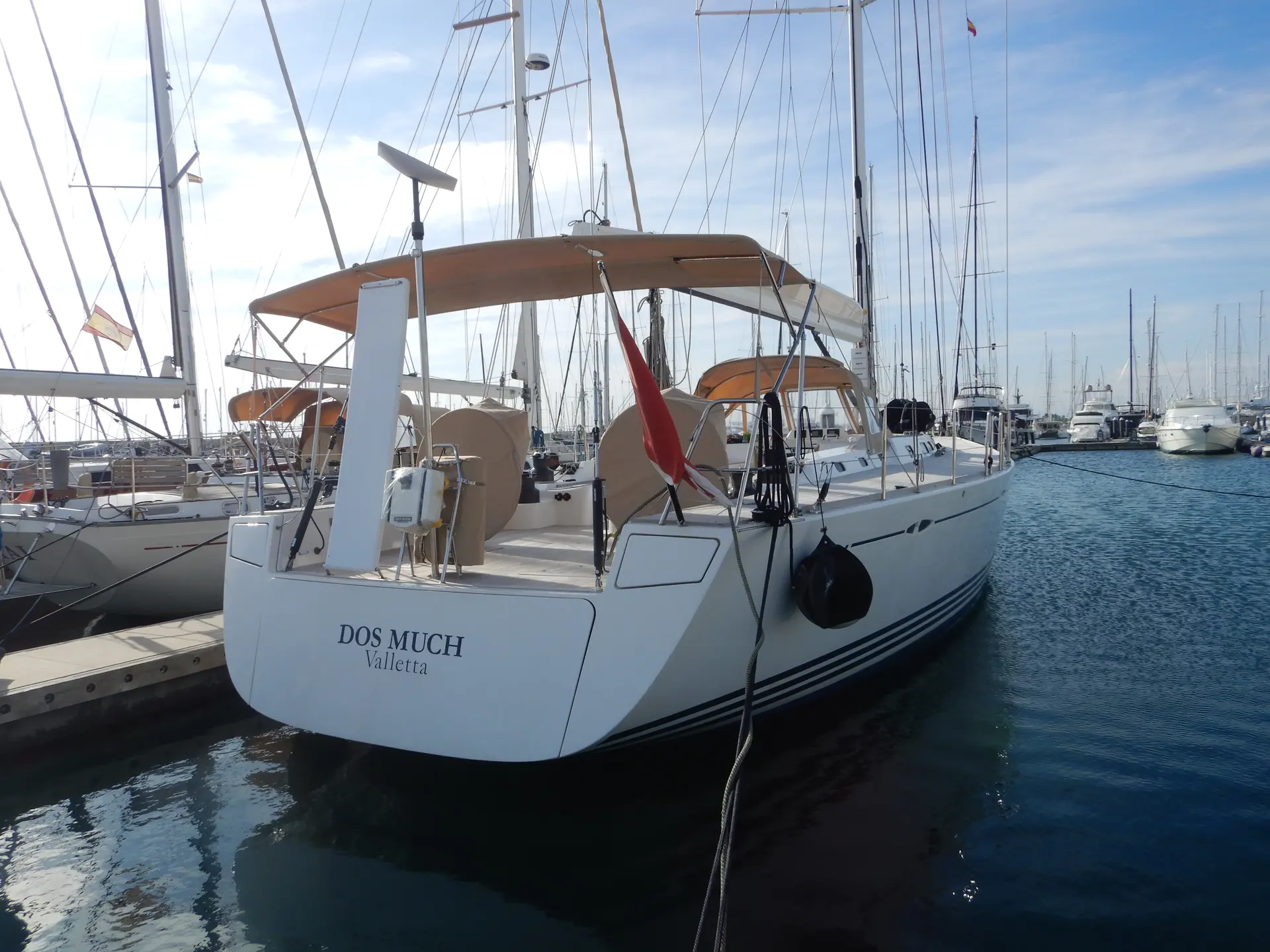 X-Yachts X-65 — Voilier blanc vu de trois quarts arrière dans une marina.
