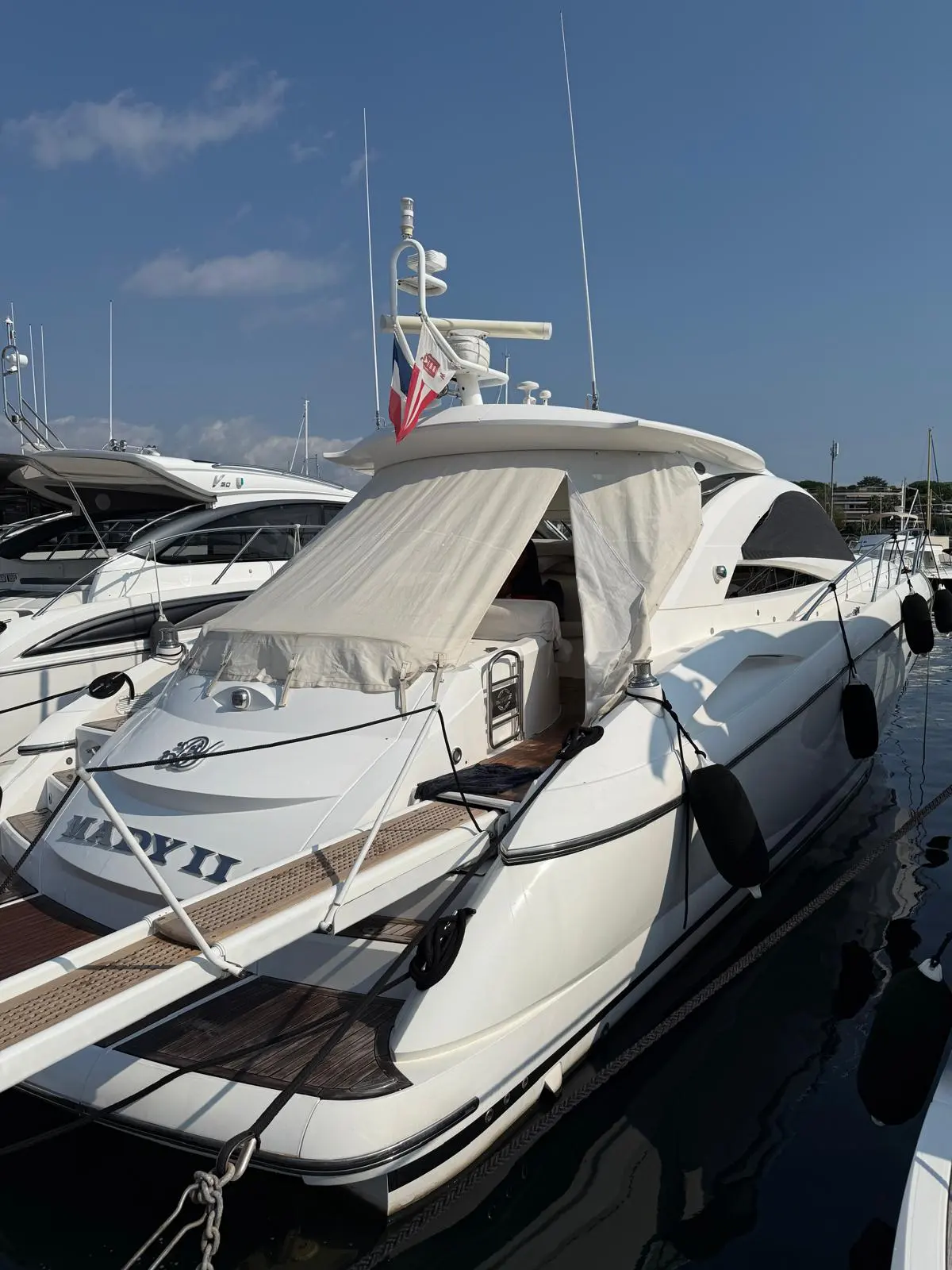 Sunseeker Portofino 53 — Bateau à moteur blanc amarré dans une marina, vu de trois quarts avant.