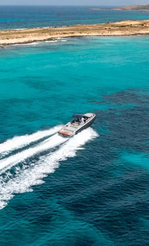 Sacs Rebel 40 — Bateau à moteur naviguant au large d’une côte turquoise.