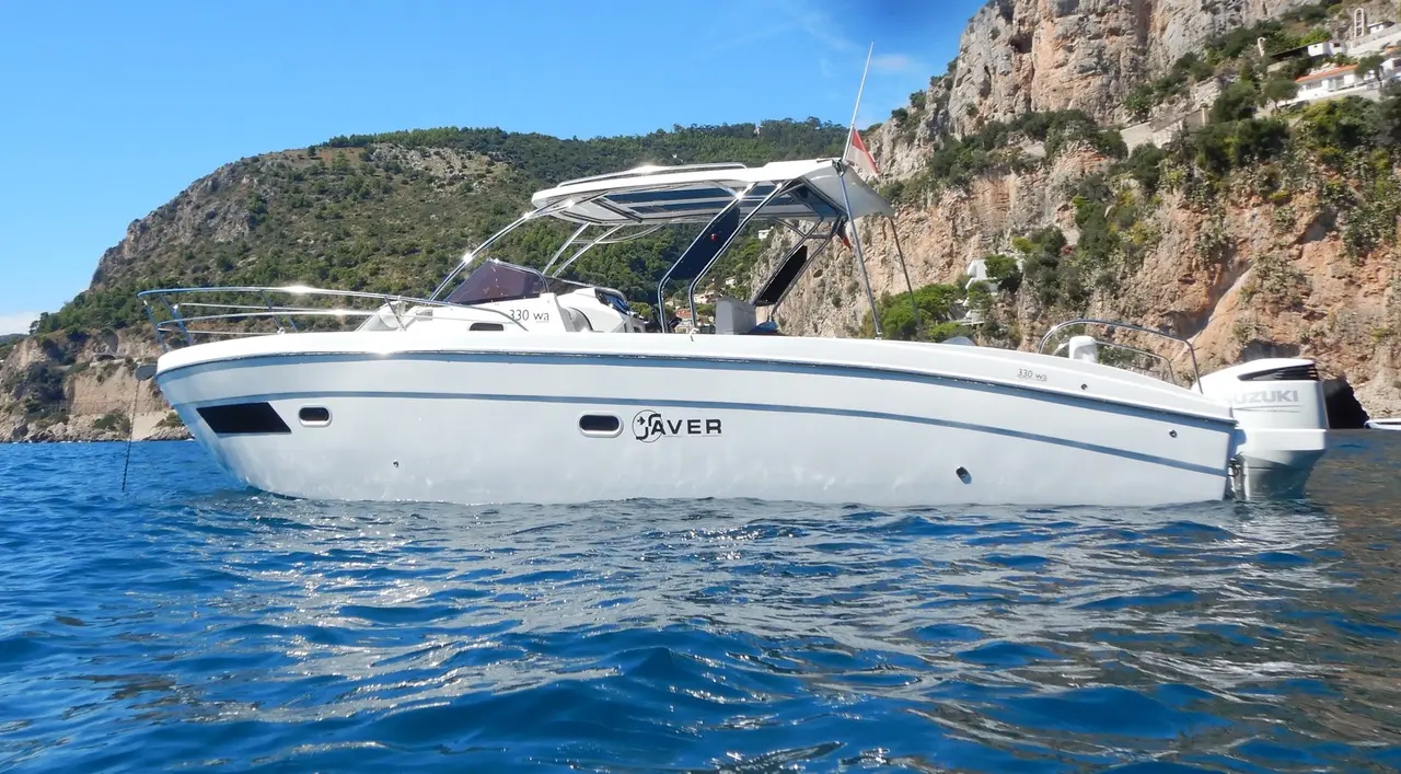 Saver 300 Walk Around — Bateau à moteur vu de profil dans une crique bordée de falaises.