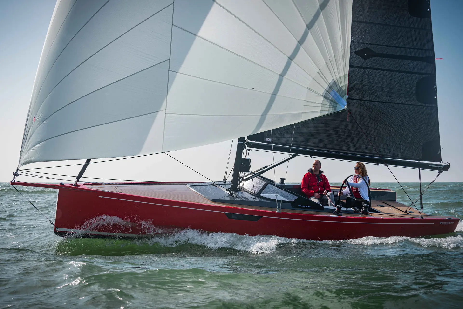 Saffier SE 27 Leisure — Voilier rouge naviguant au près, toutes voiles hissées sur une mer agitée.