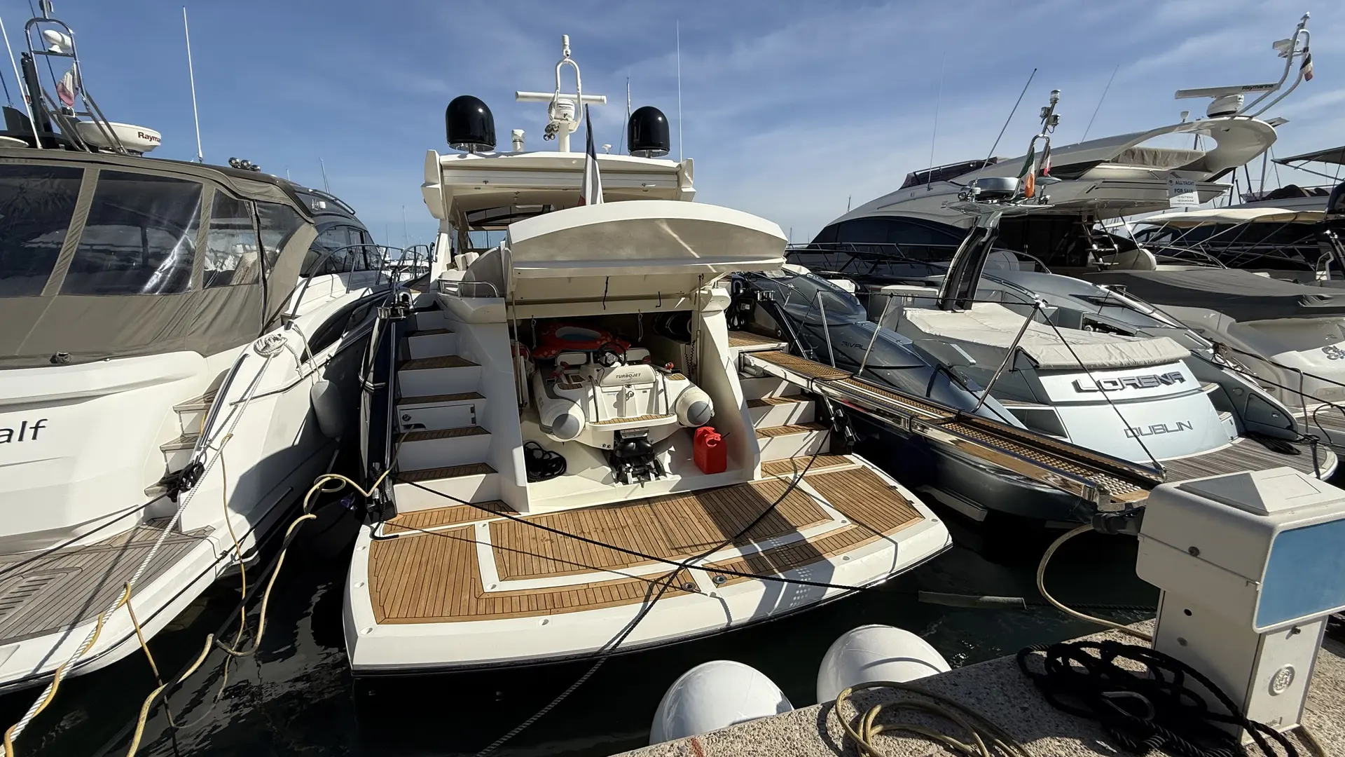 Sunseeker Predator 60 — Vue arrière d’un yacht amarré, avec plateforme et annexe visibles.