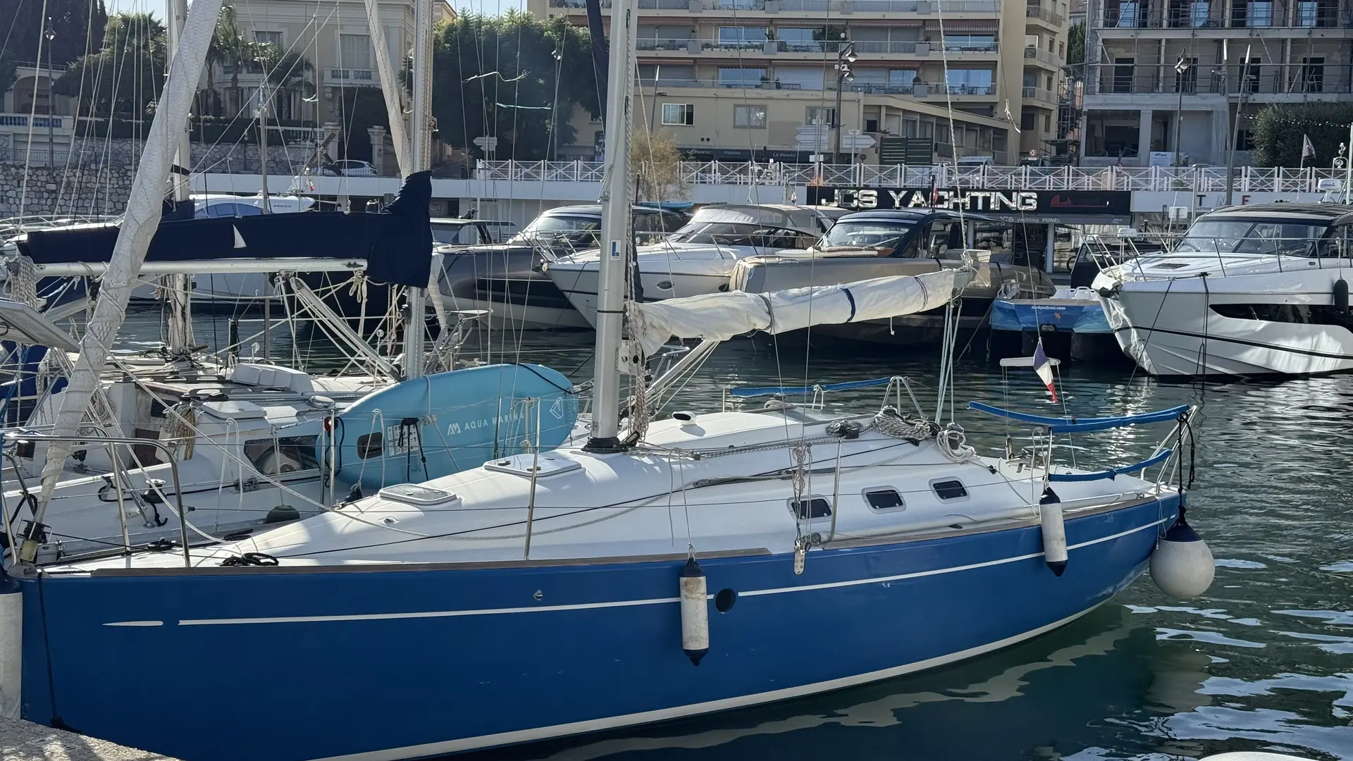Beneteau First 300 Spirit — Voilier bleu et blanc amarré dans une marina, vu de trois quarts bâbord.