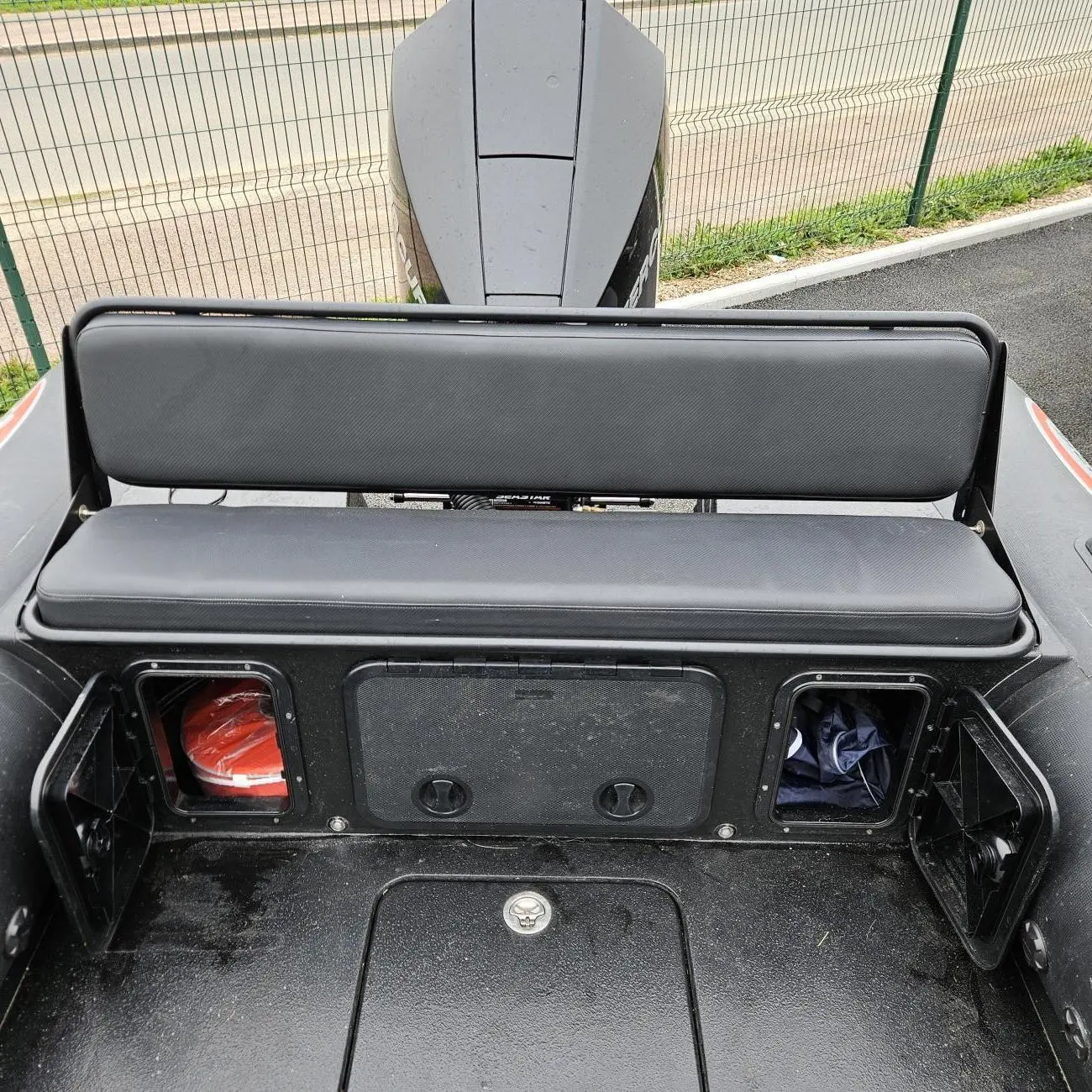 Searib`s Searib 670 — Vue arrière du bateau montrant une banquette, des coffres et un moteur hors-bord.