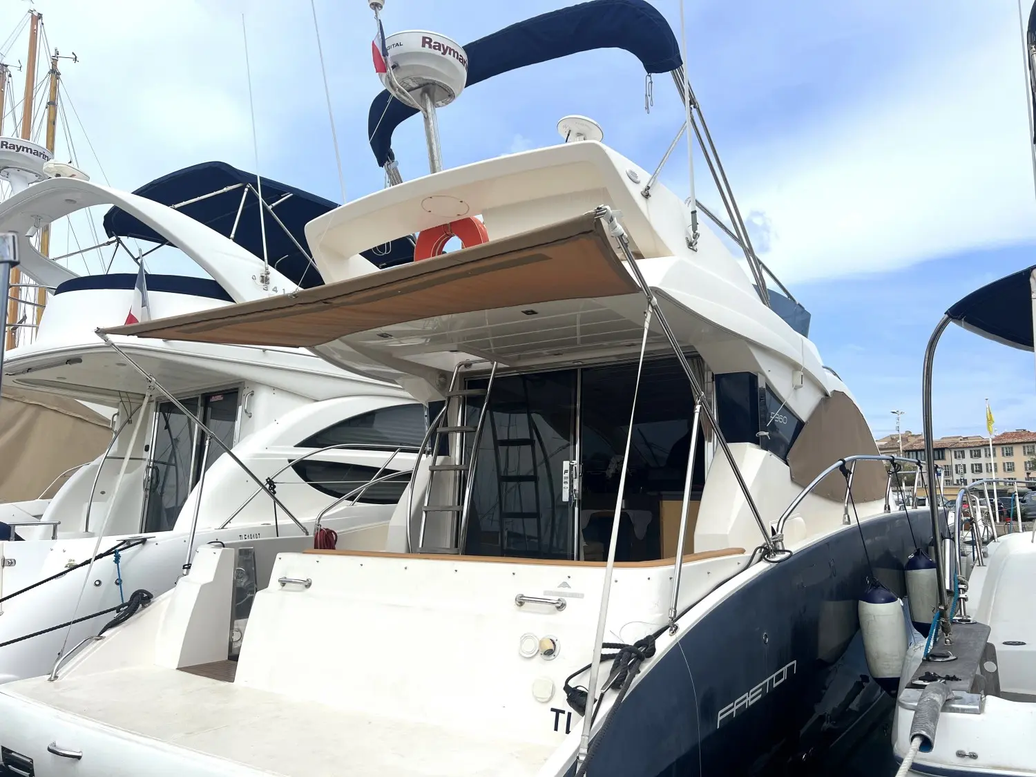 Faeton F-360 Fly — Vue arrière trois-quarts d’un bateau à moteur amarré dans un port.
