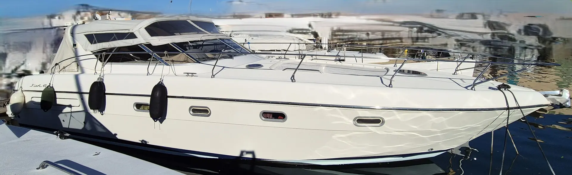 Fiart Mare Fiart 40 — Bateau à moteur blanc amarré à un quai, vu de profil sur l’eau.