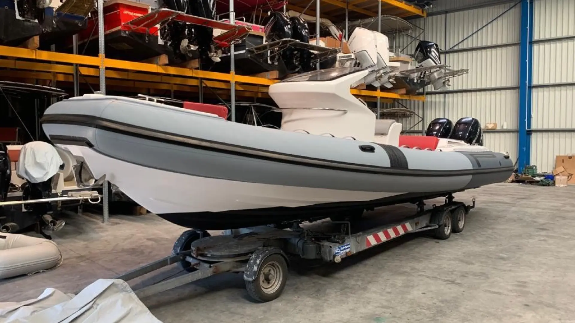 Pirelli Pzero 880 L — Bateau semi-rigide gris et blanc présenté sur sa remorque dans un hangar.
