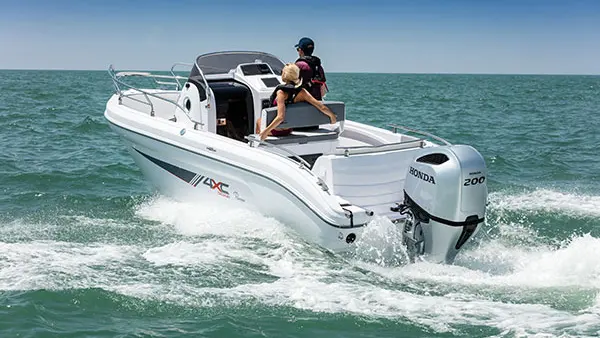 4XC H22SD — Bateau à moteur vu de trois quarts arrière, en navigation avec deux personnes à bord.