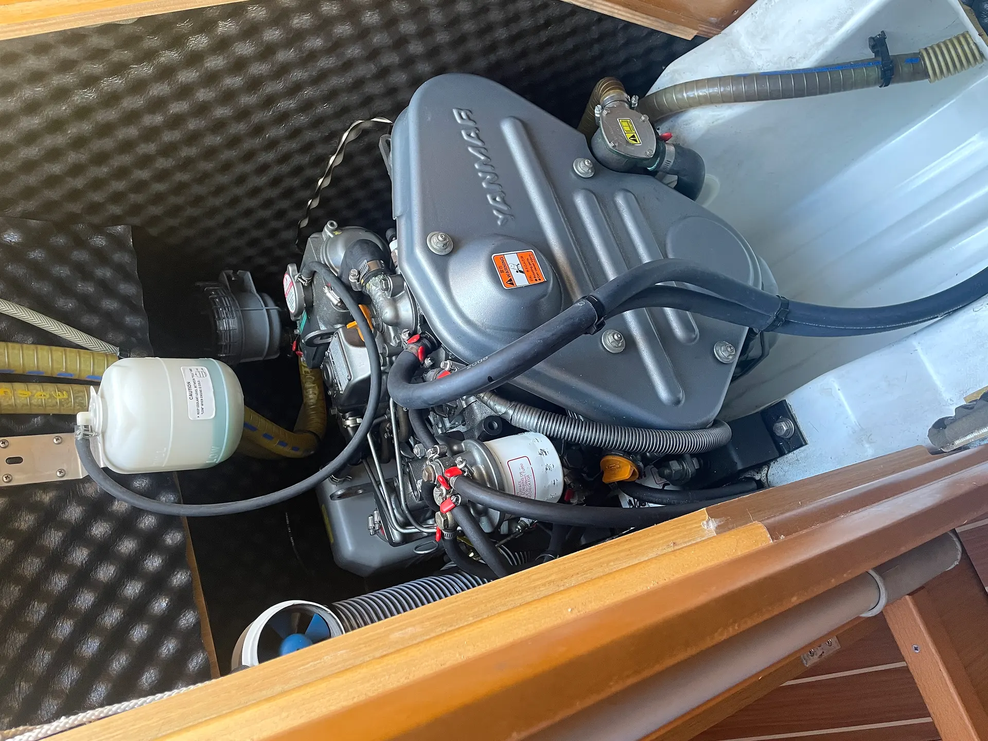 Jeanneau Sun Odyssey 39 — Vue rapprochée du moteur et de ses conduites dans le compartiment moteur.